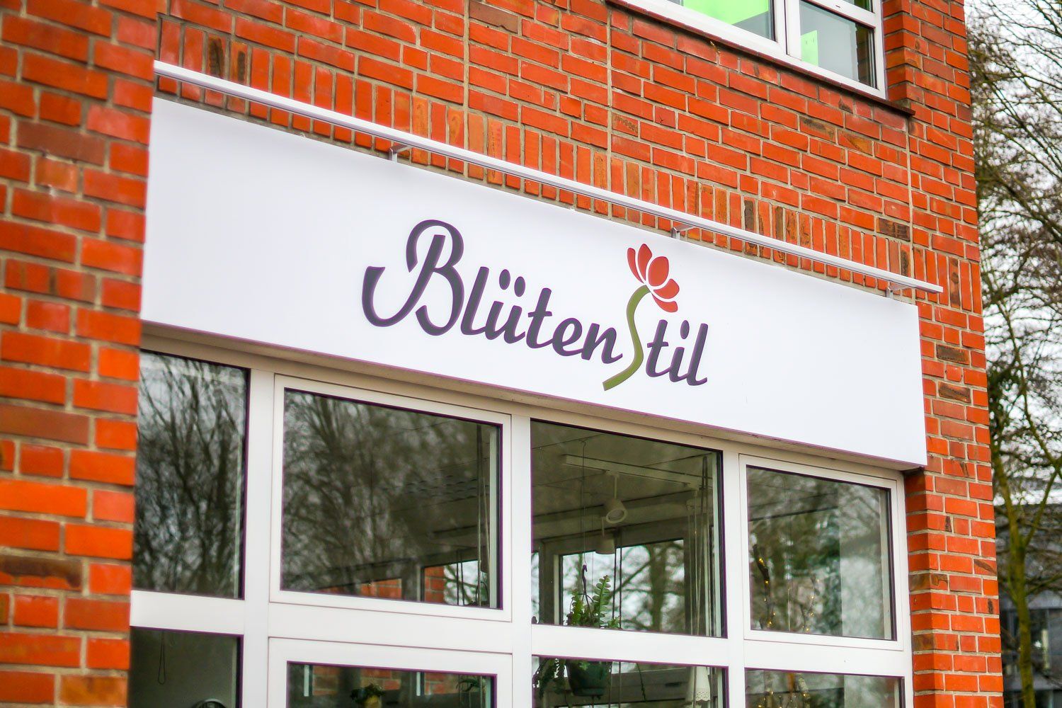 Ein Backsteingebäude mit einem Schild mit der Aufschrift „Blumenstil“ darauf.