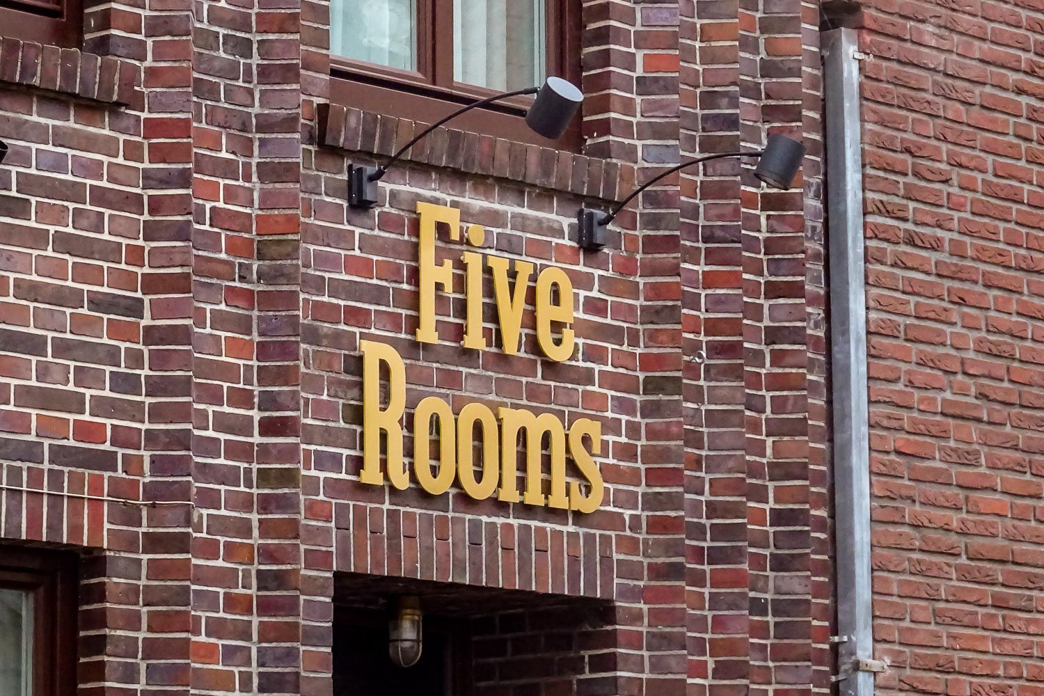 Ein Backsteingebäude mit einem Schild mit der Aufschrift „Fünf Zimmer“