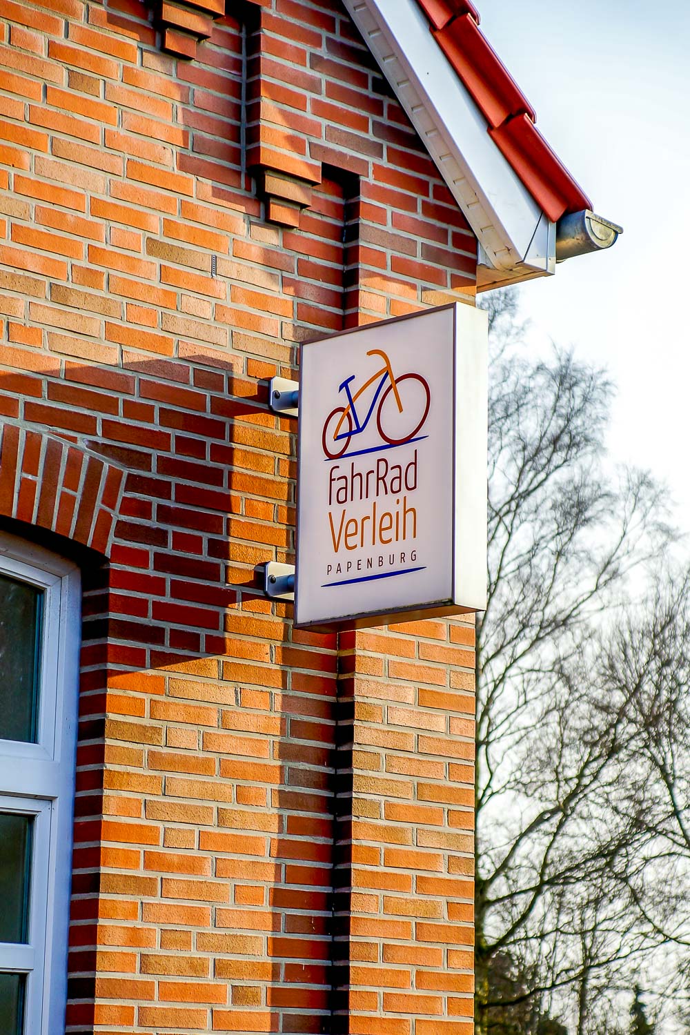 Ein Schild an der Seite eines Backsteingebäudes sagt Fahrrad Verleih
