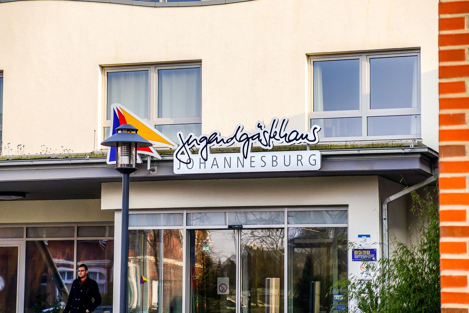 Ein Mann steht vor dem Eingang eines Gebäudes mit einem Schild mit der Aufschrift Yanvesburg