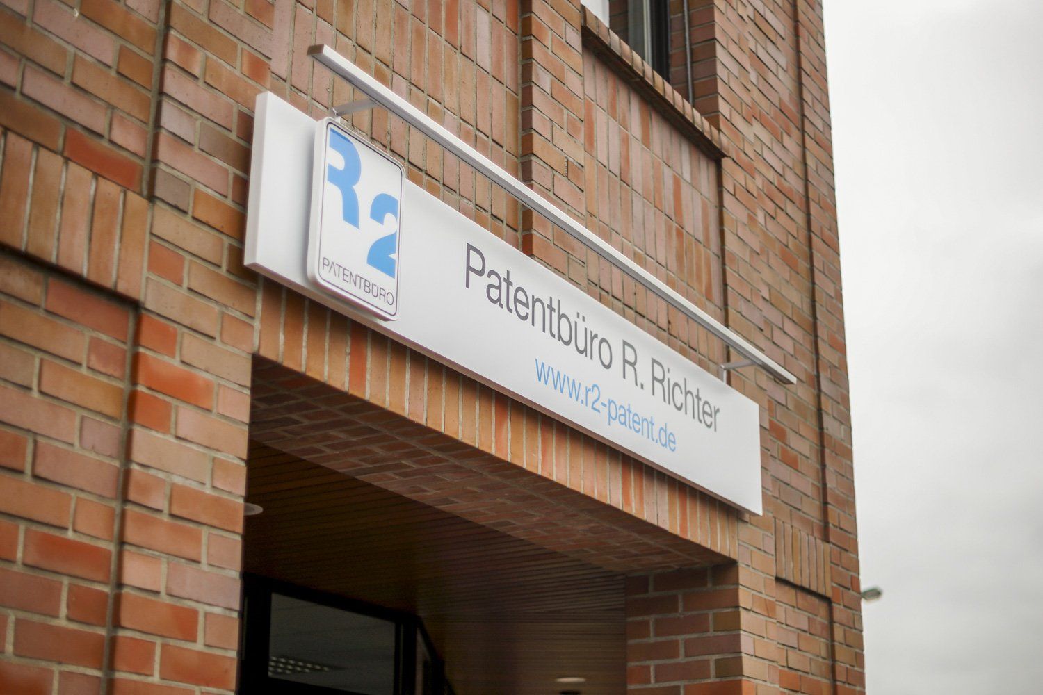 Ein Backsteingebäude mit einem Schild mit der Aufschrift „Patentbüro R. Richter“.