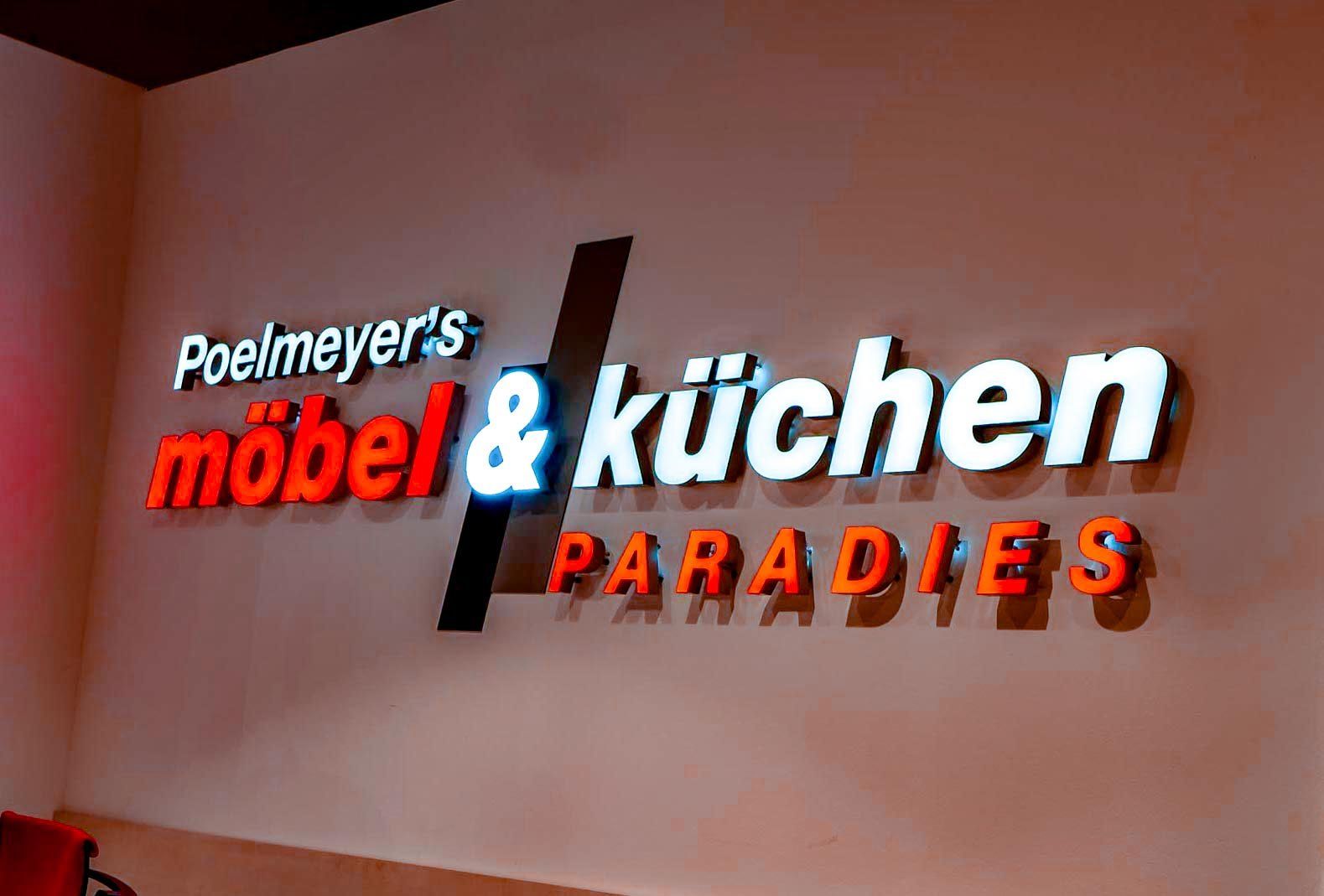 A sign that says ' poelmeyer 's mobel & kuchen paradies ' on it