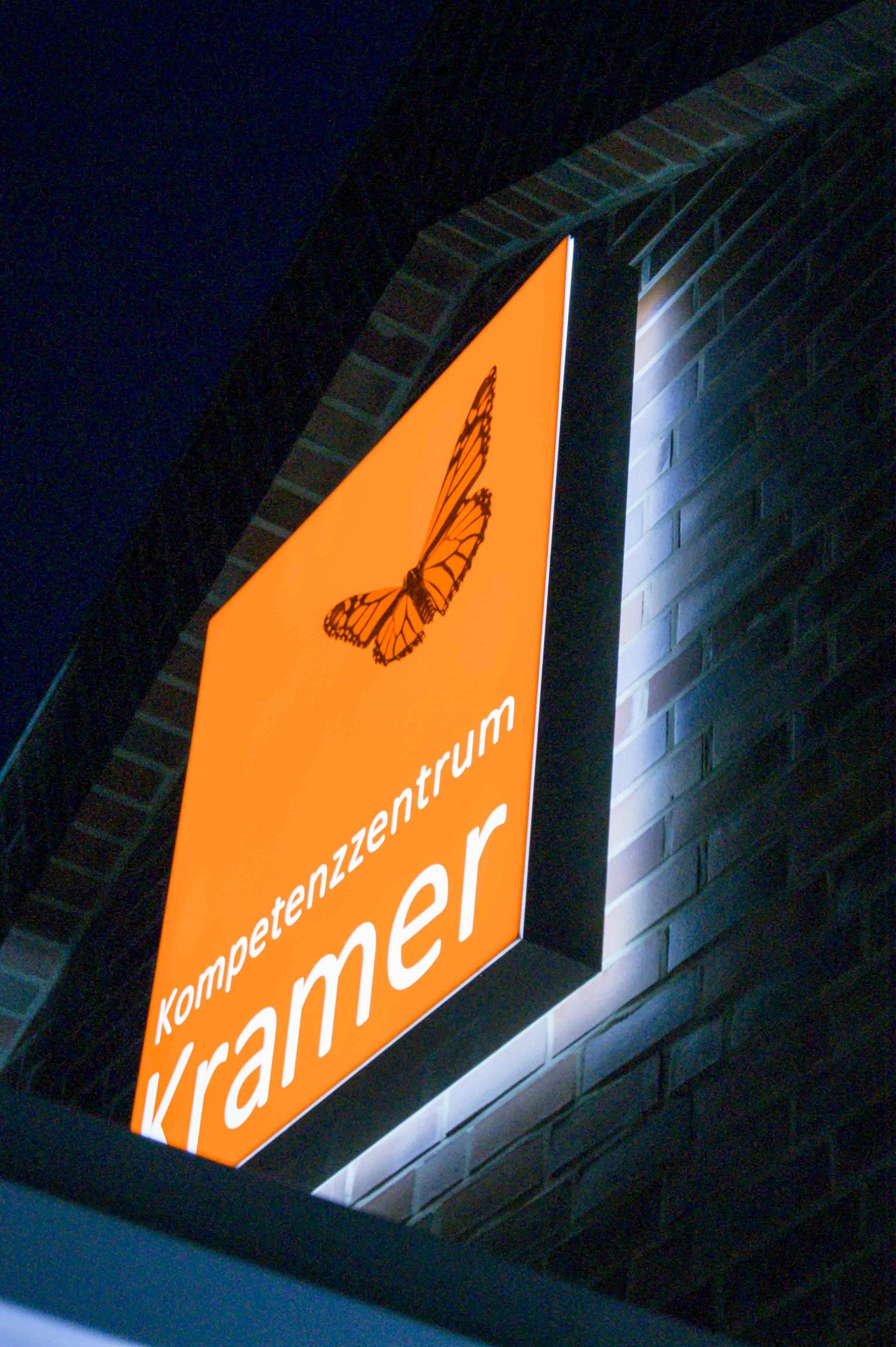 Ein Schild an einer Backsteinmauer mit der Aufschrift „Kramer“