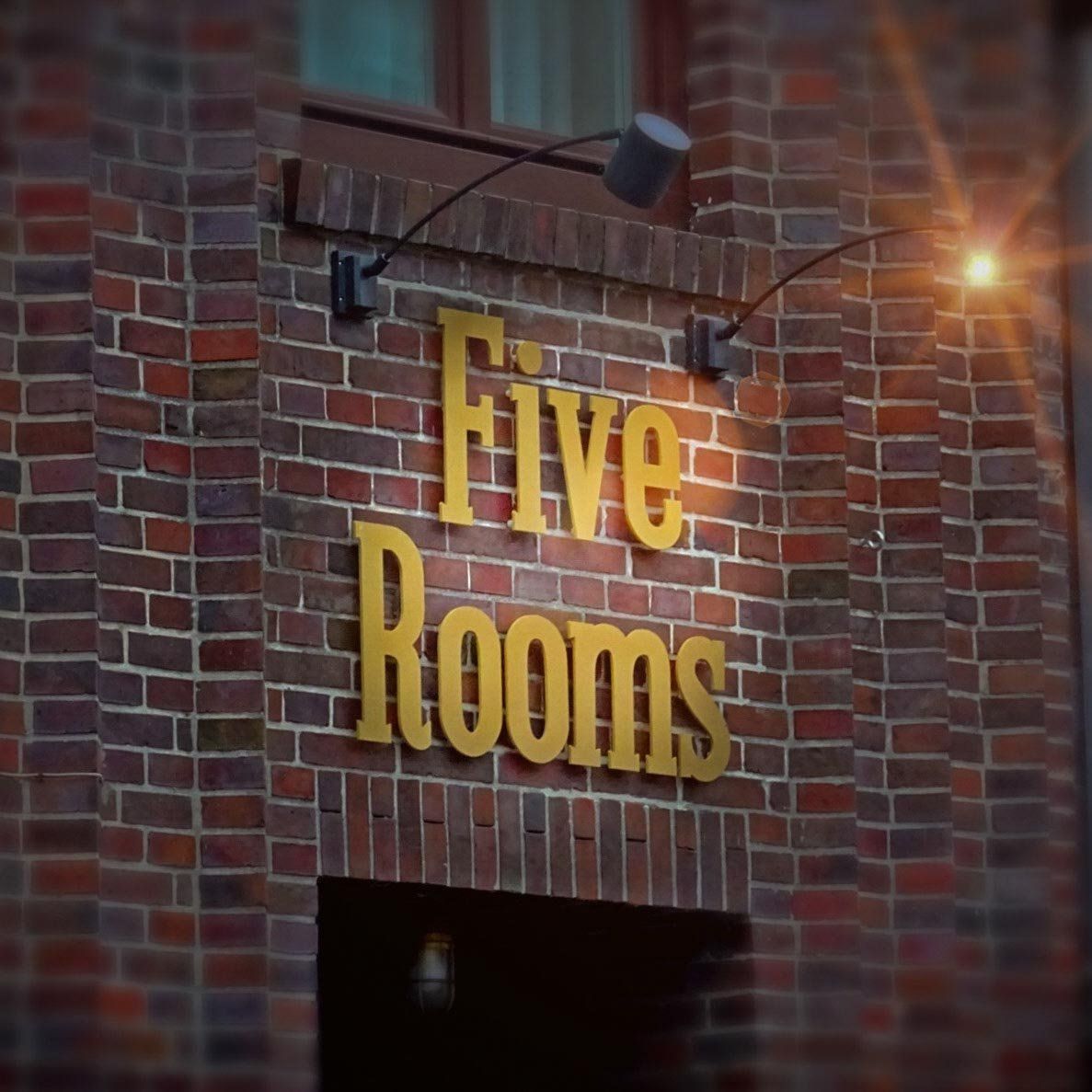 Ein Backsteingebäude mit einem Schild mit der Aufschrift „Fünf Zimmer“