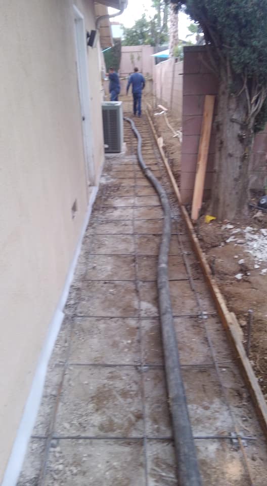 A man is walking down a sidewalk next to a house.