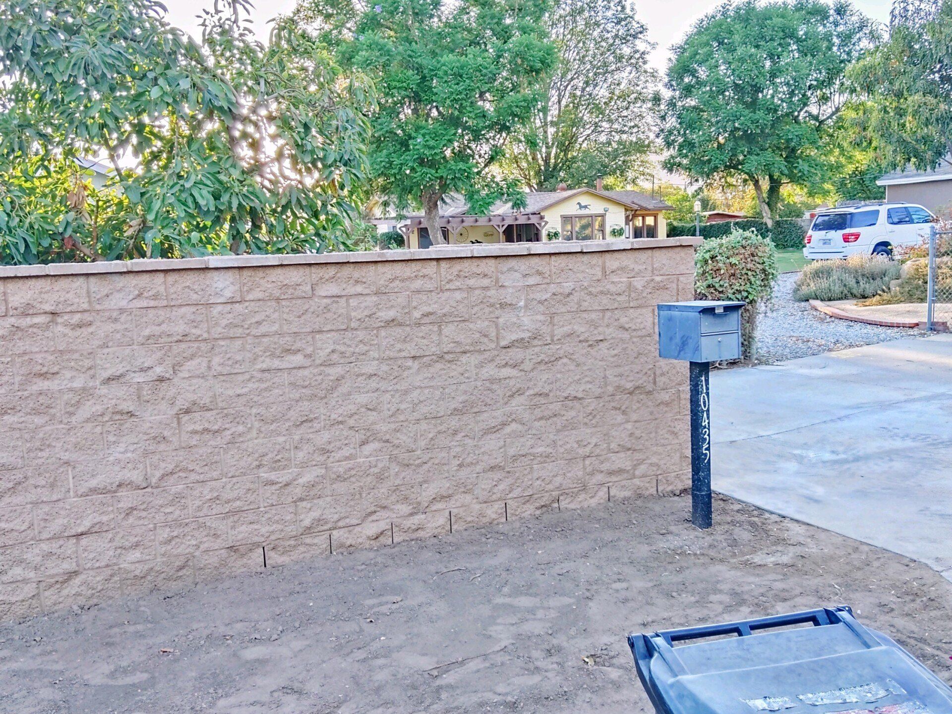 A brick wall with a mailbox in front of it.