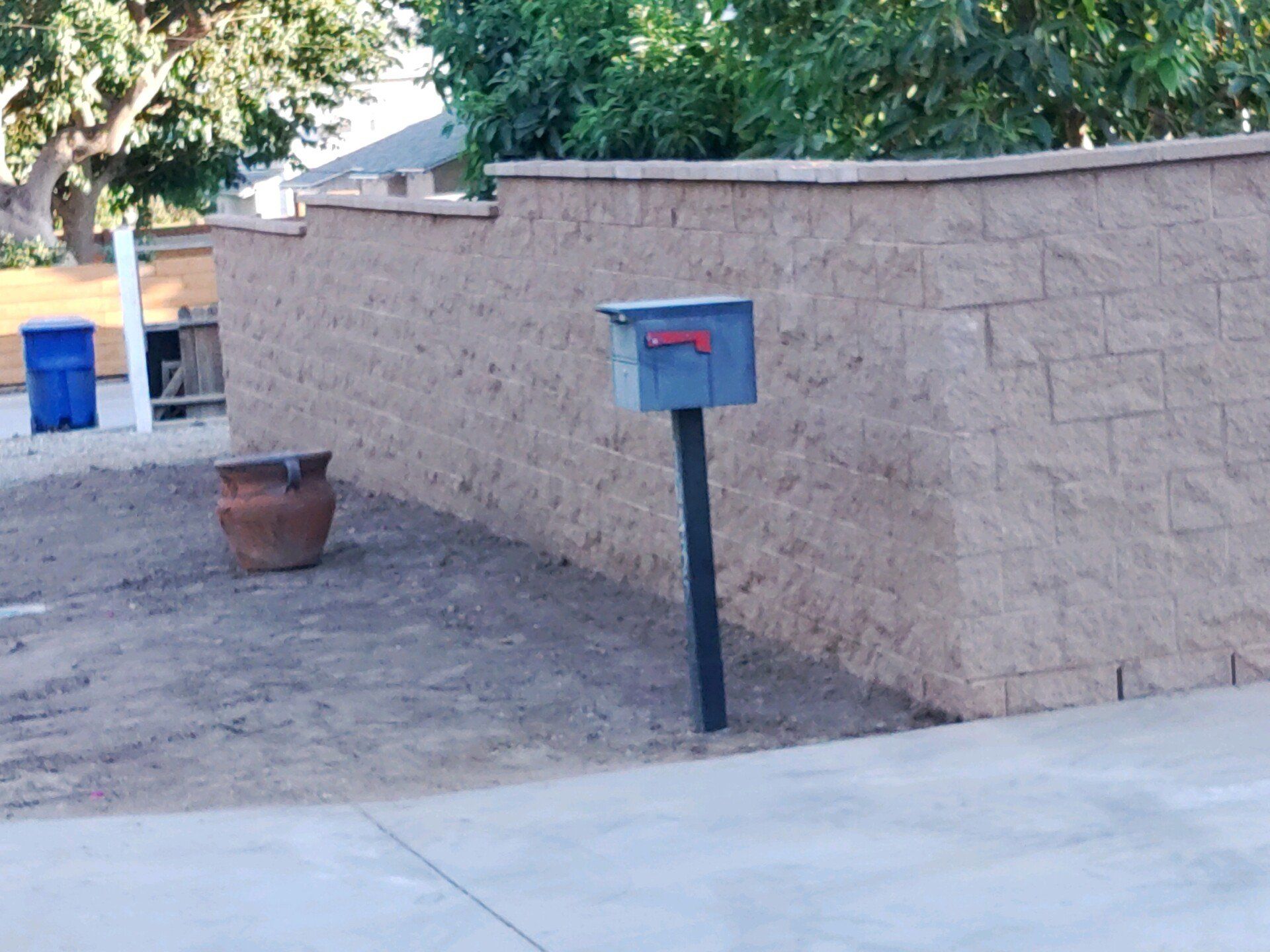 A brick wall with a mailbox in front of it
