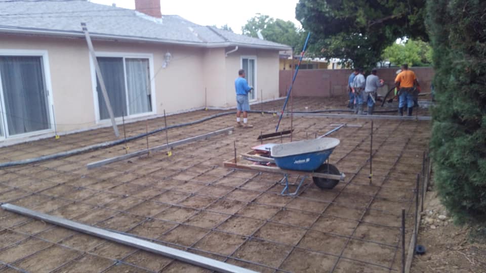 A wheelbarrow is sitting on the ground in front of a house.