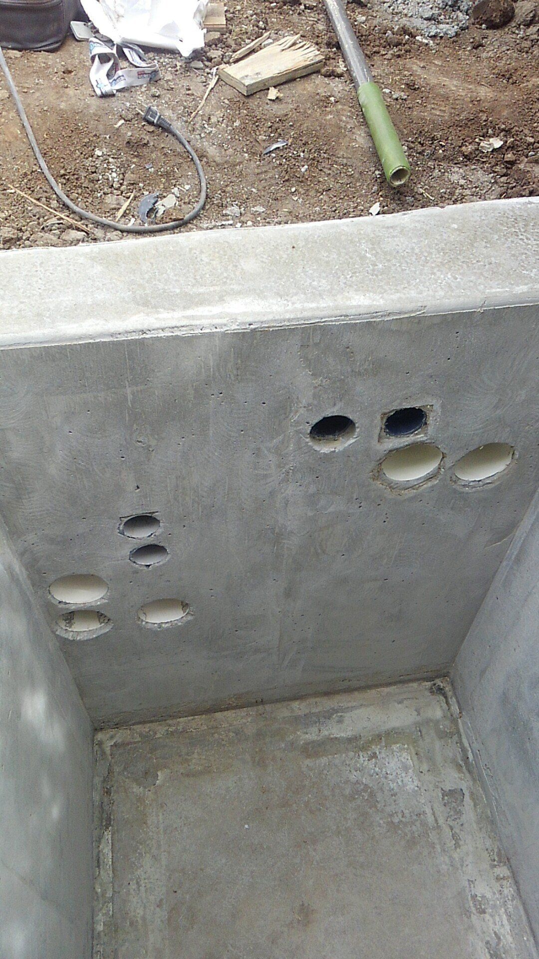 A close up of a concrete wall with holes in it.