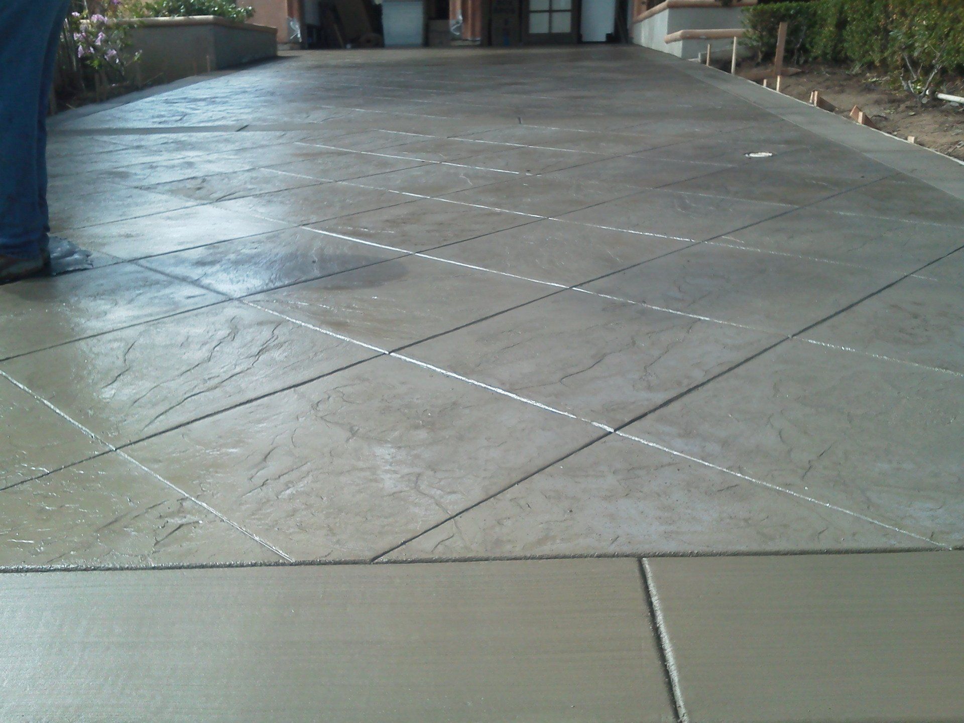A concrete driveway with a diagonal pattern on it