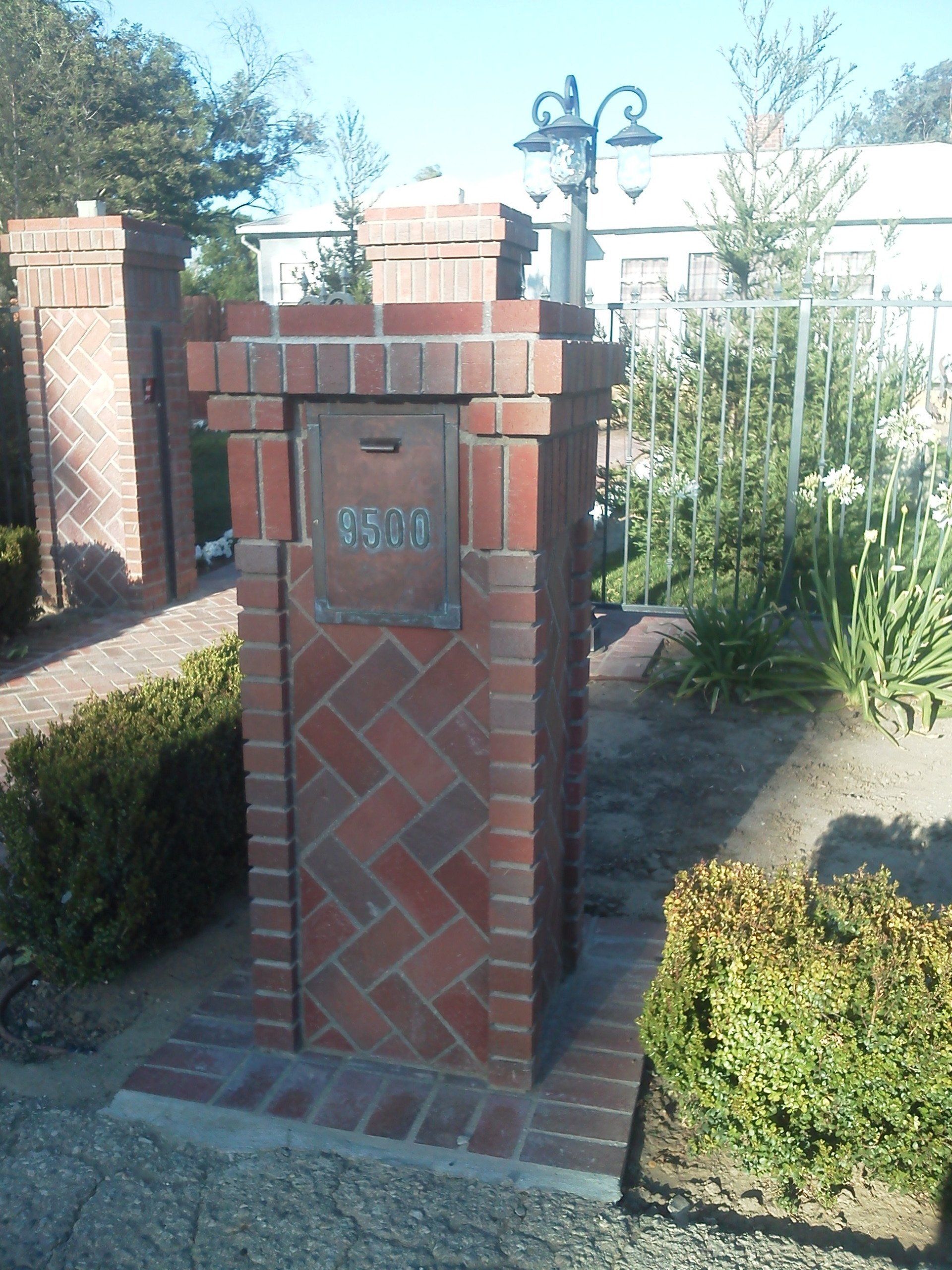 A brick pillar with a mailbox on top of it