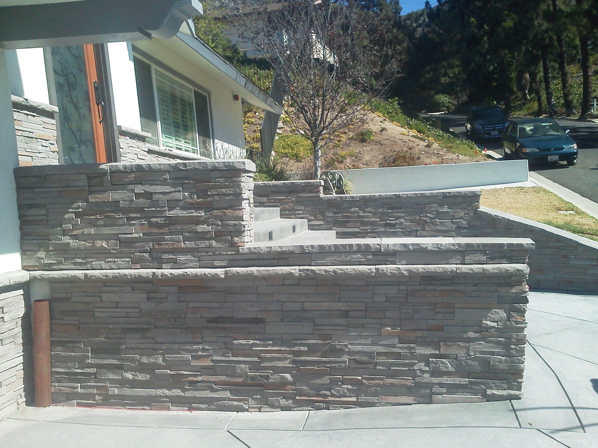 A stone wall with stairs leading up to a house