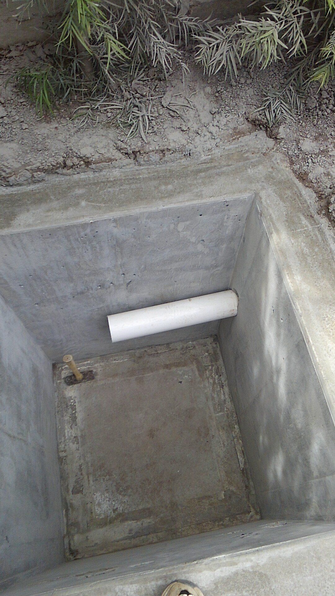 A concrete box with a pipe in the middle of it.