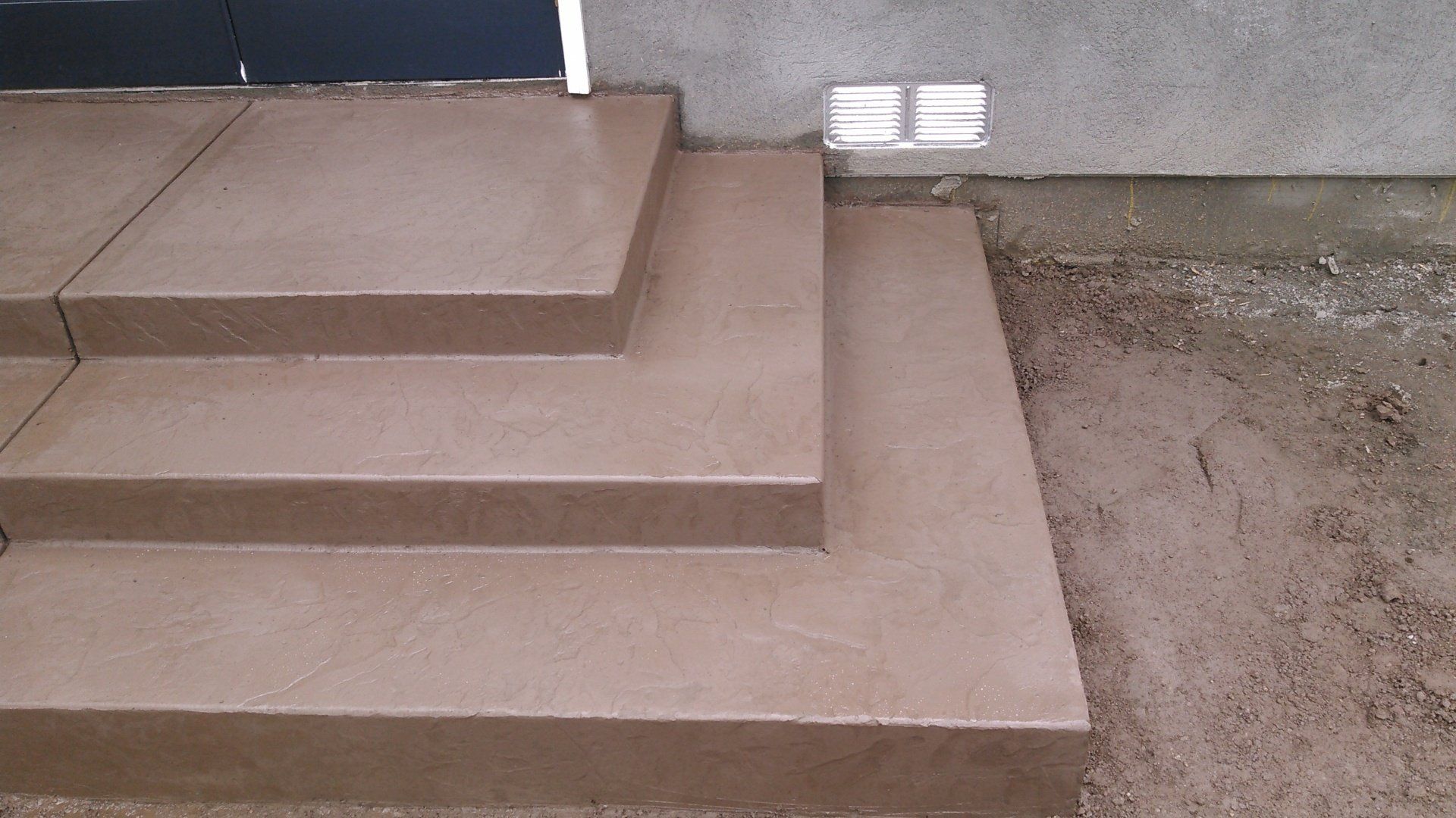 A set of concrete steps leading up to a house.