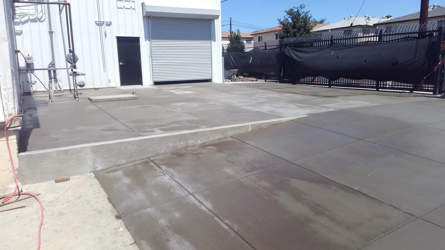 A concrete driveway is being built in front of a building.