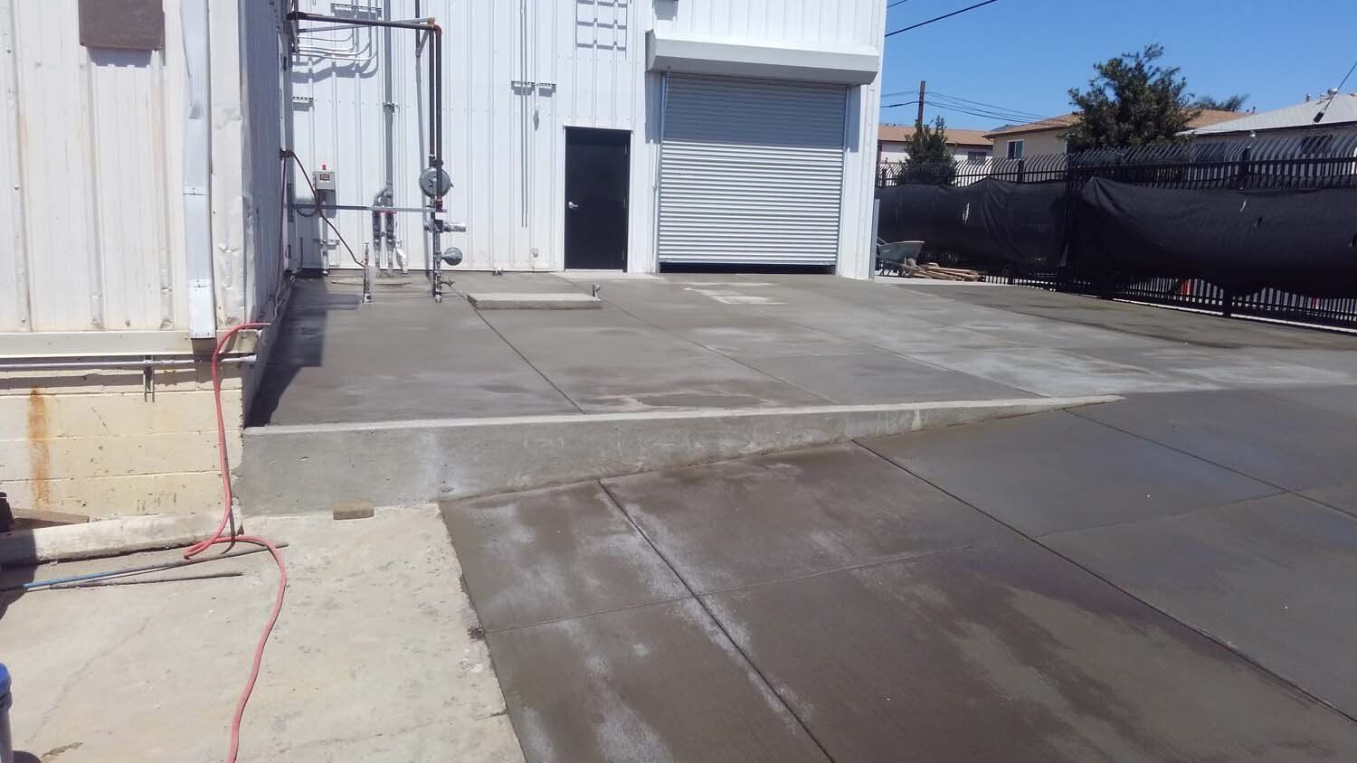 A concrete driveway is being built in front of a building.