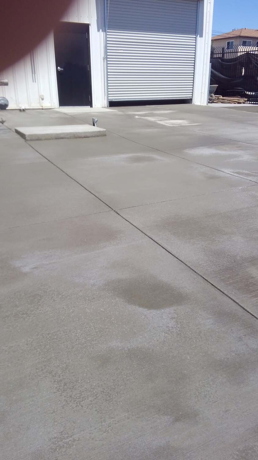 A concrete driveway with a garage door in the background.