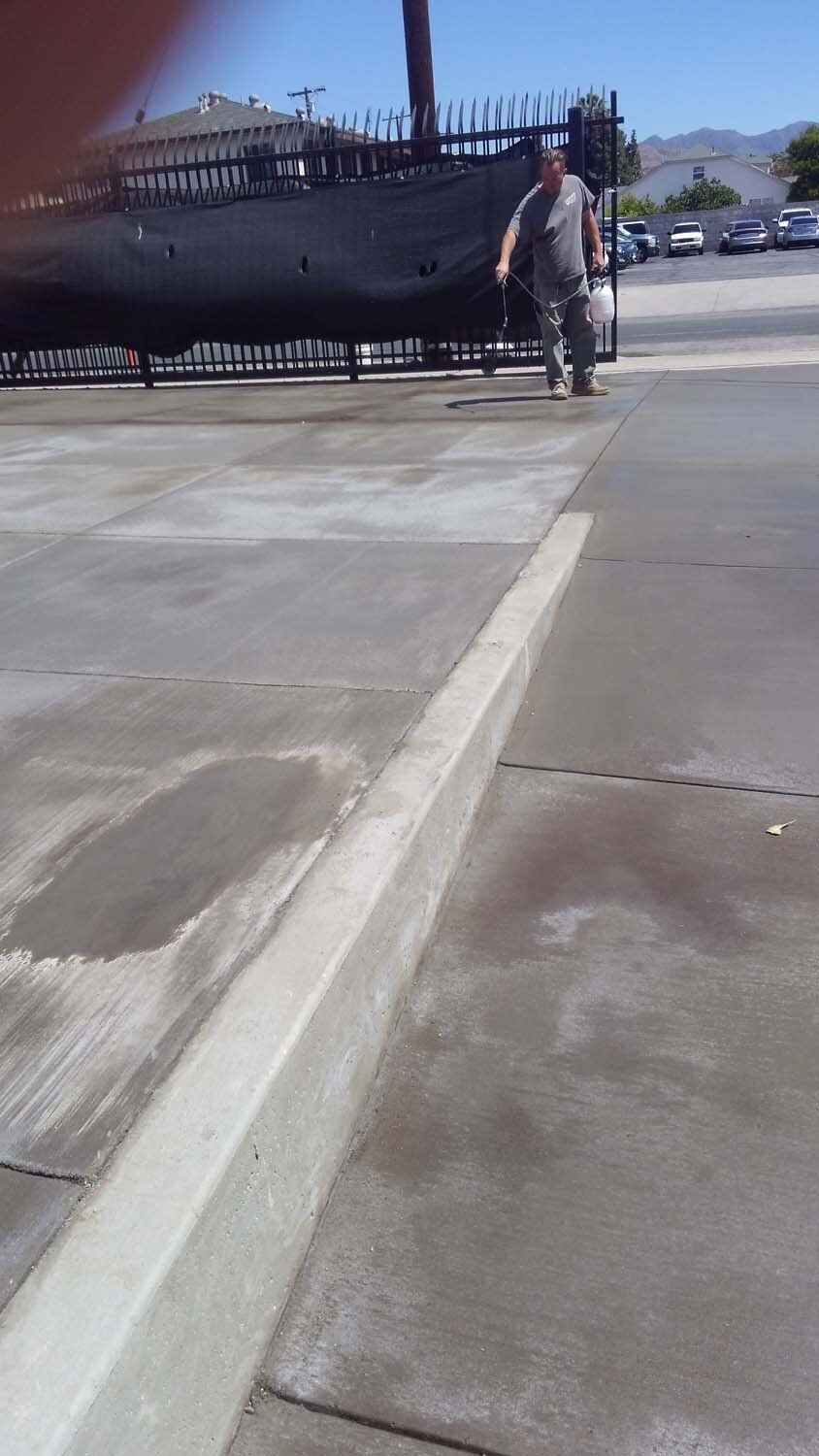 A man is walking down a sidewalk next to a boat.
