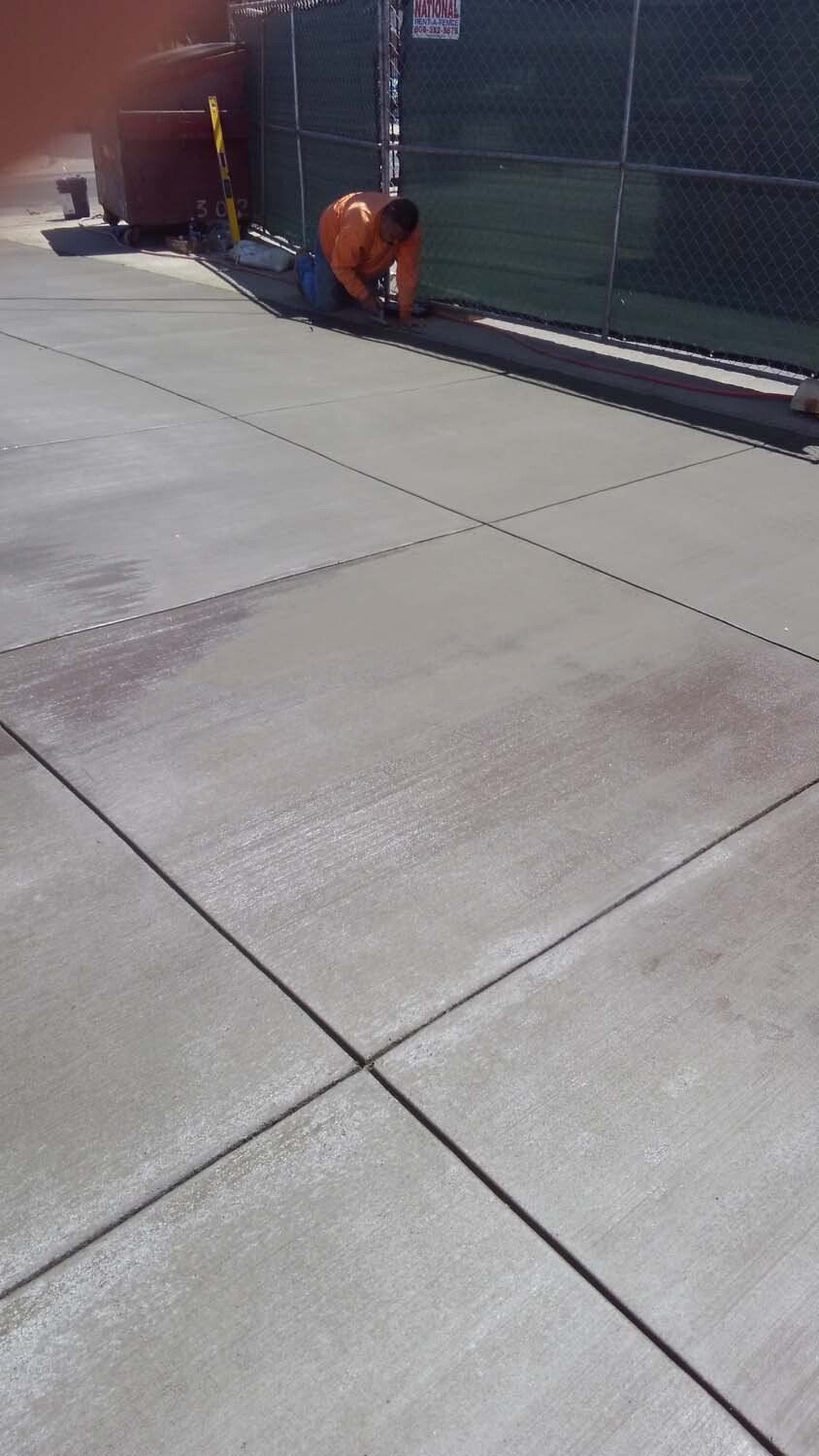 A man is kneeling down on a concrete floor