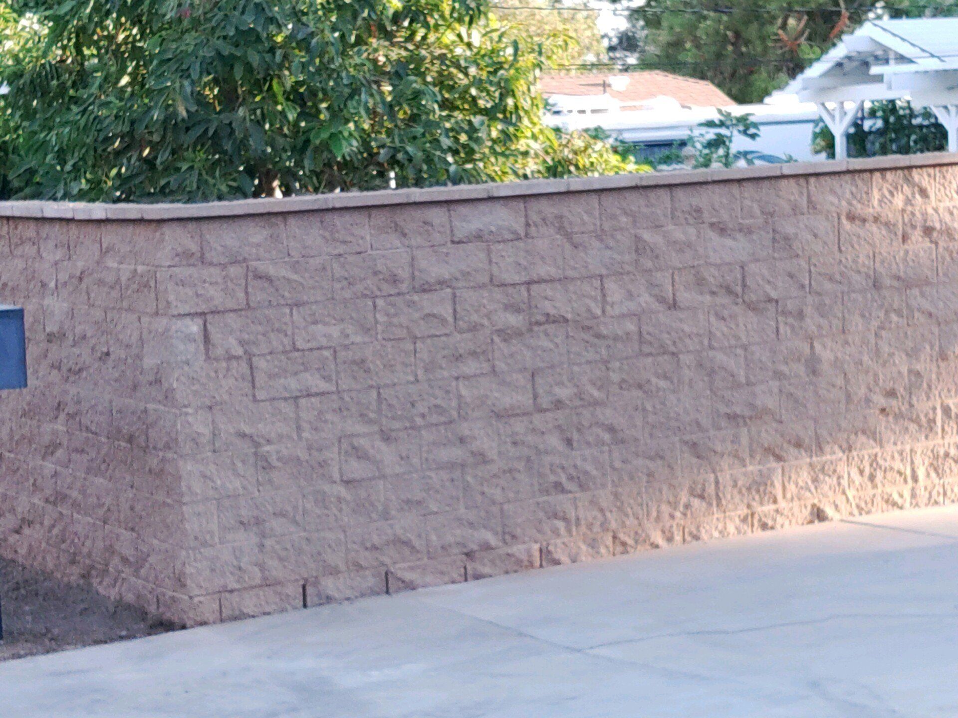 A brick wall with a blue mailbox on it