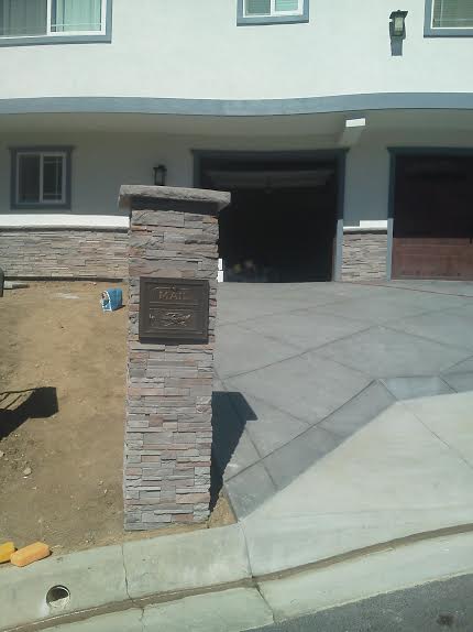 A white house with a brick pillar in front of it