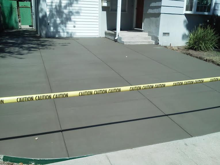 A concrete driveway with a caution tape around it
