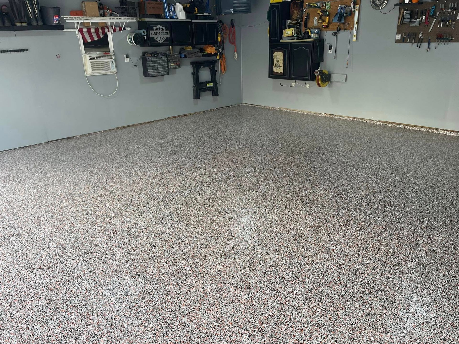 Garage with epoxy speckled flooring and gray walls.