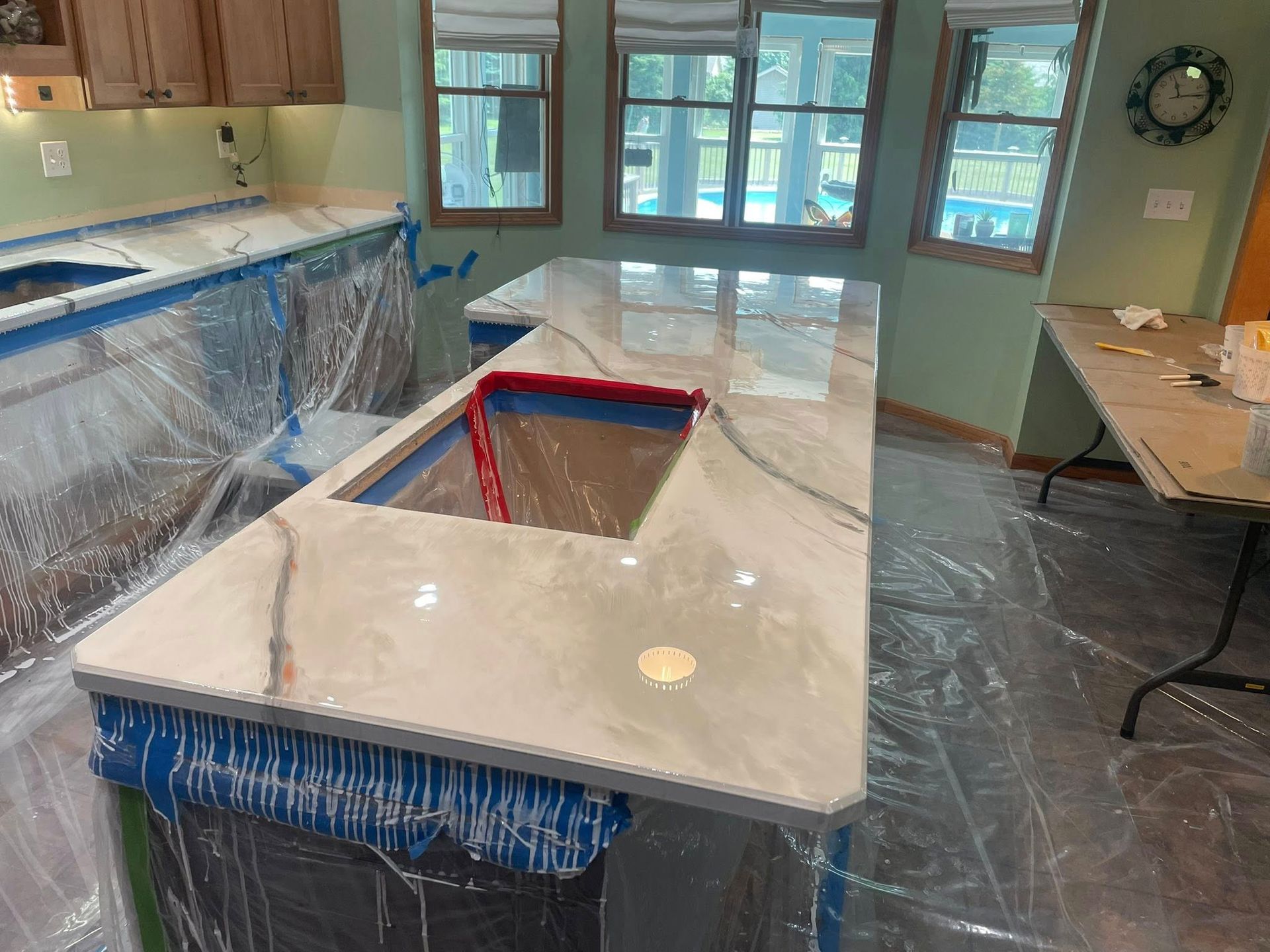 Newly installed kitchen countertop with light veining, protected with plastic wrap.