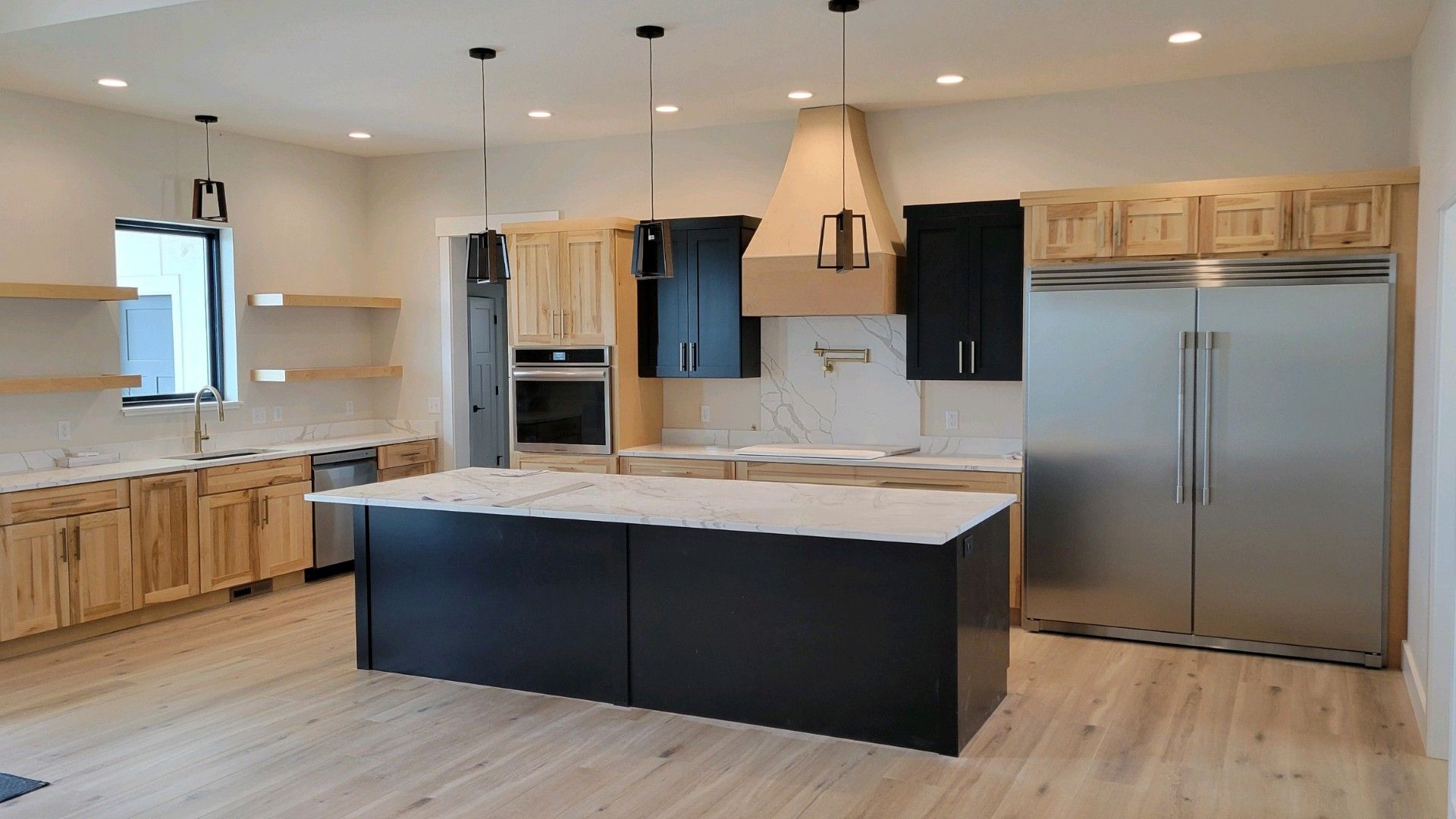 A kitchen with white cabinets and a large island in the middle