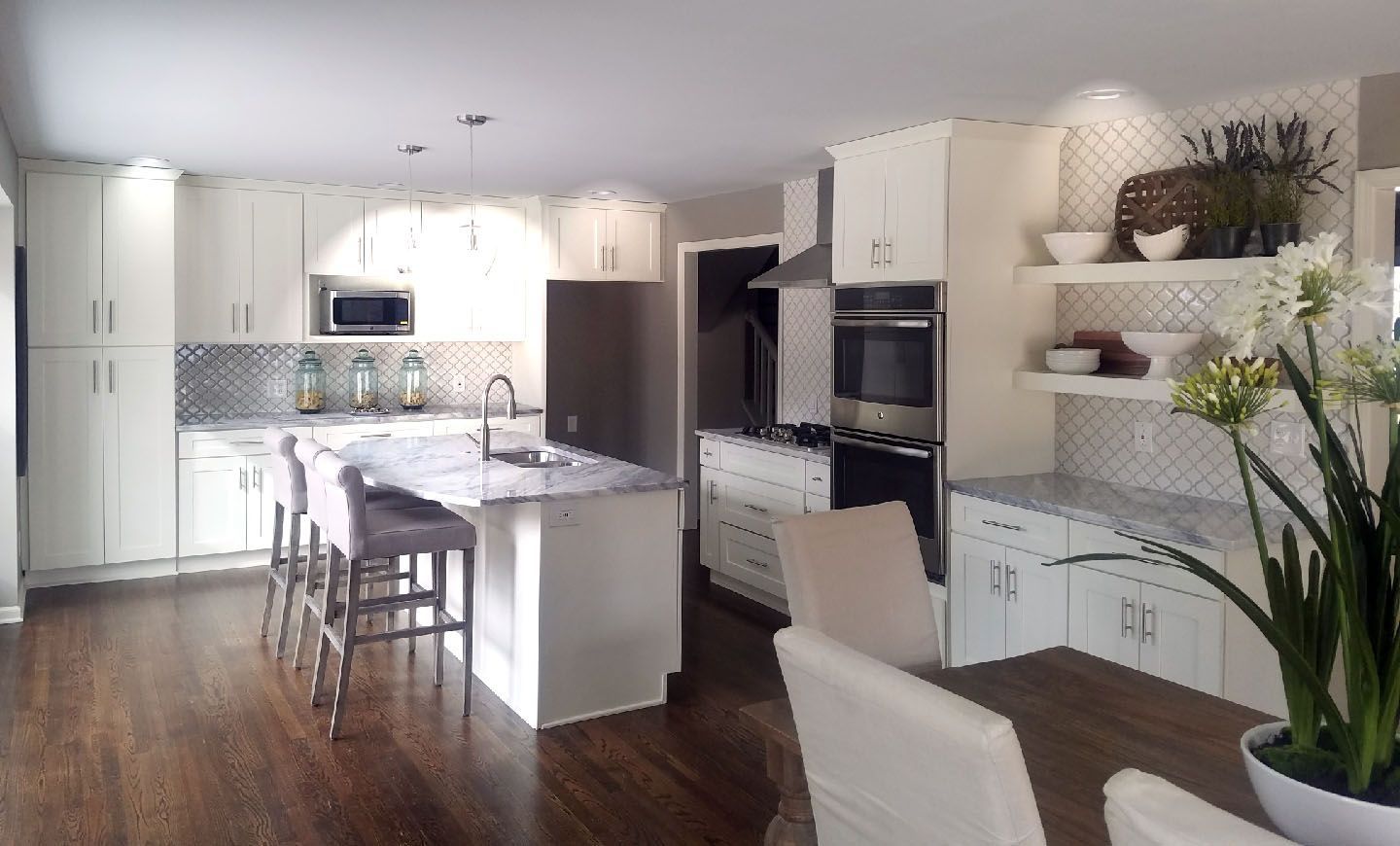 A kitchen with white cabinets and a large island in the middle.