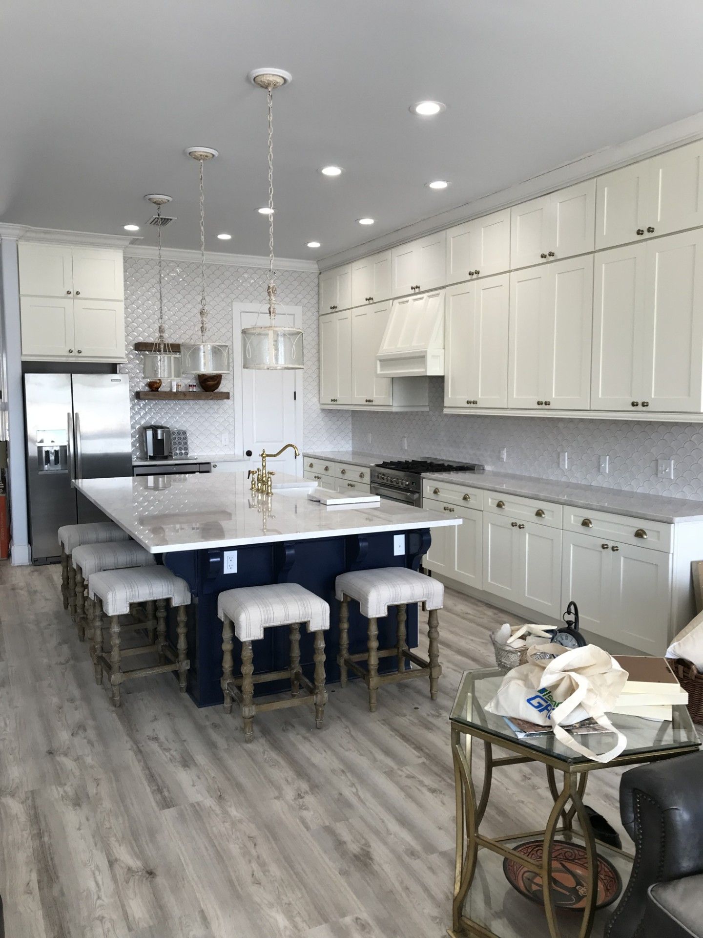 A kitchen with white cabinets and a large island in the middle.