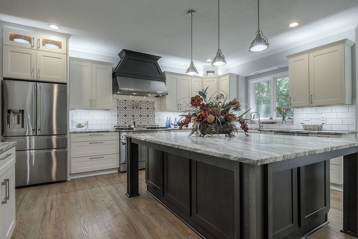 A kitchen with stainless steel appliances , granite counter tops , and a large island.