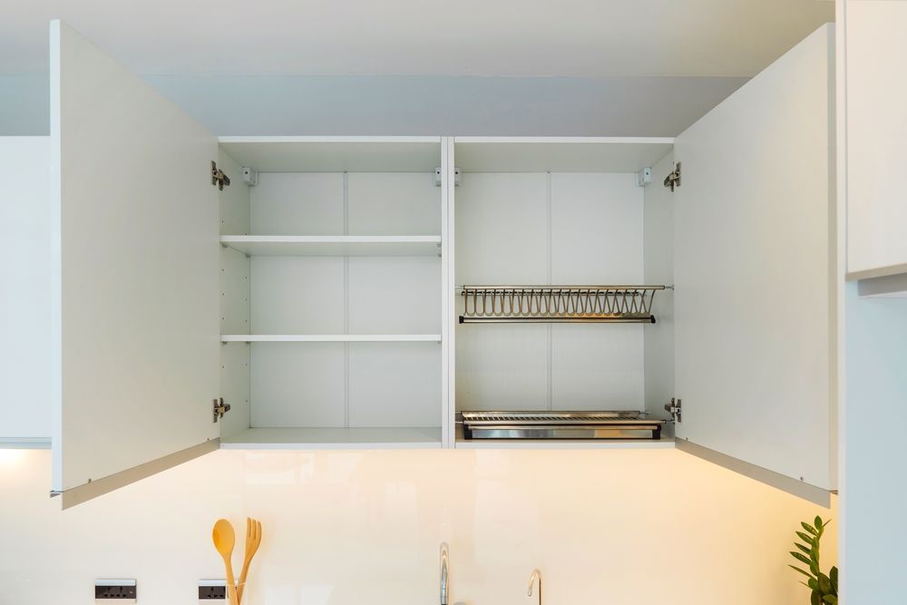 An empty cabinet in a kitchen with the doors open.