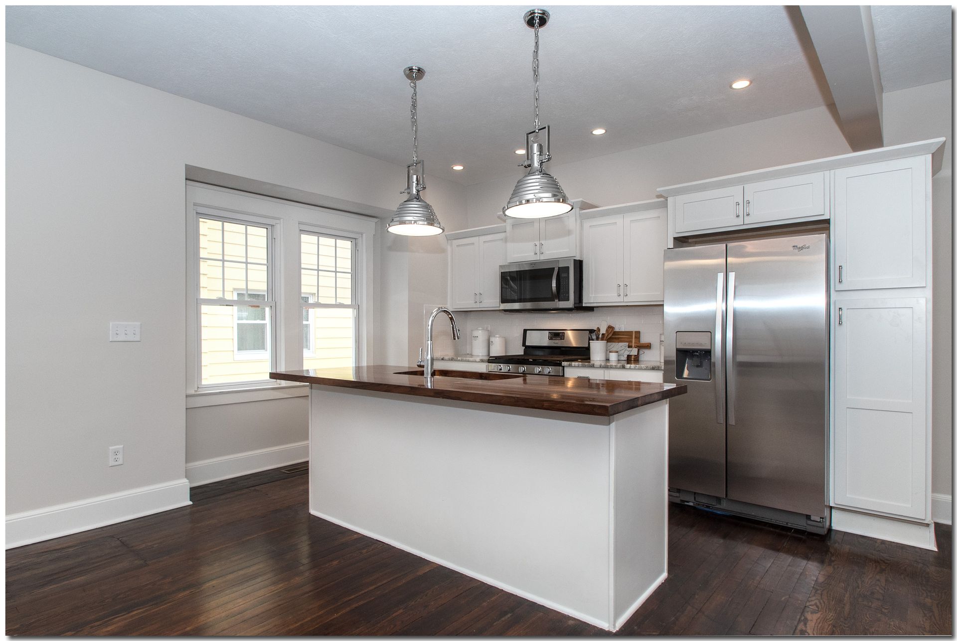 A kitchen with white cabinets and stainless steel appliances