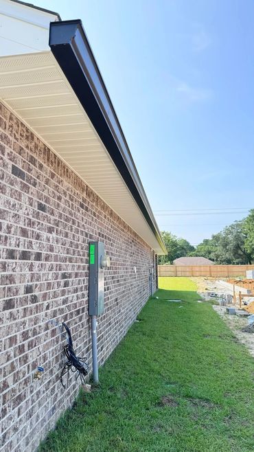A brick house with a gutter on the side of it.