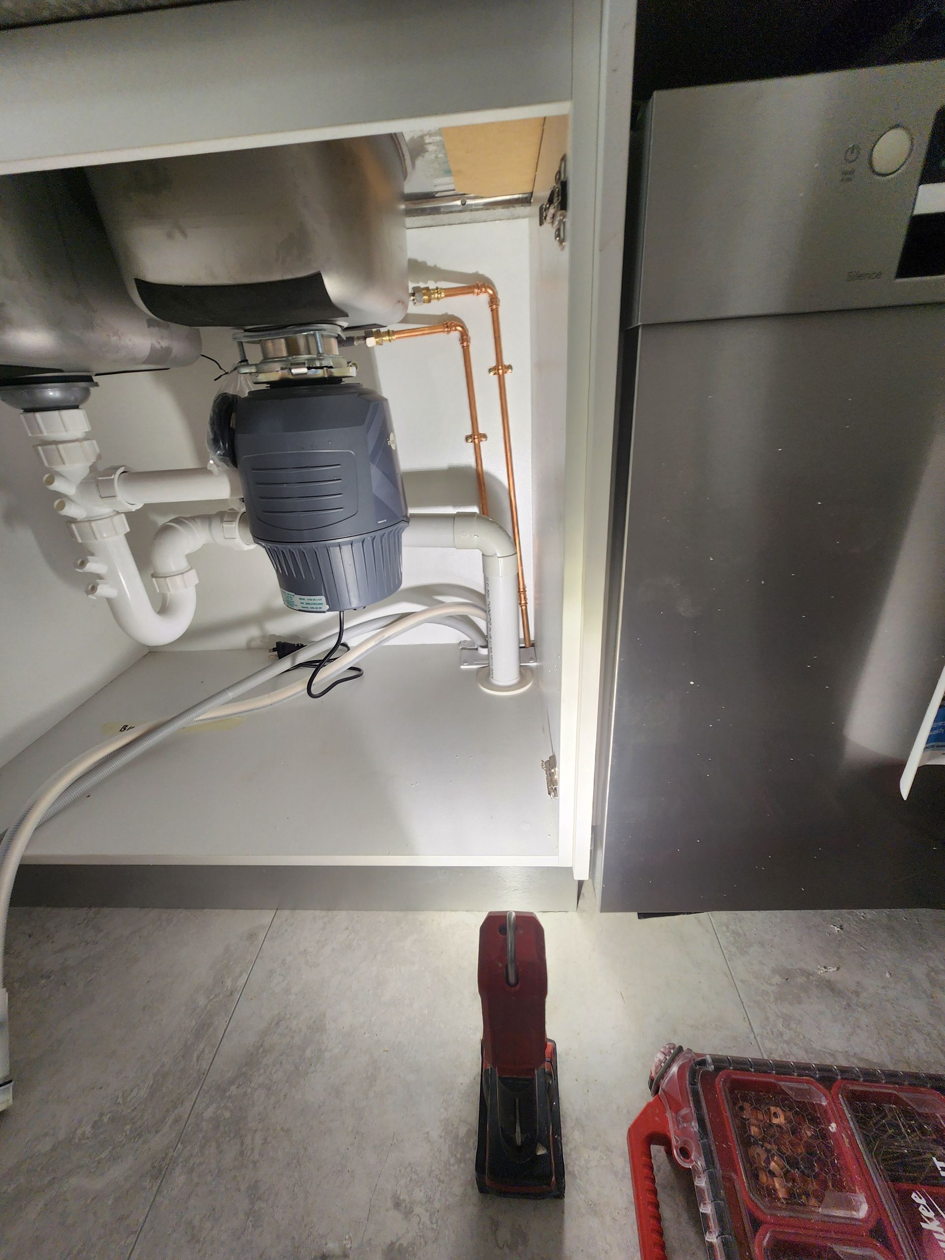 Under-sink View Showing a Grey Garbage Disposal — Kingdom Plumbing Services in Gordonvale, QLD