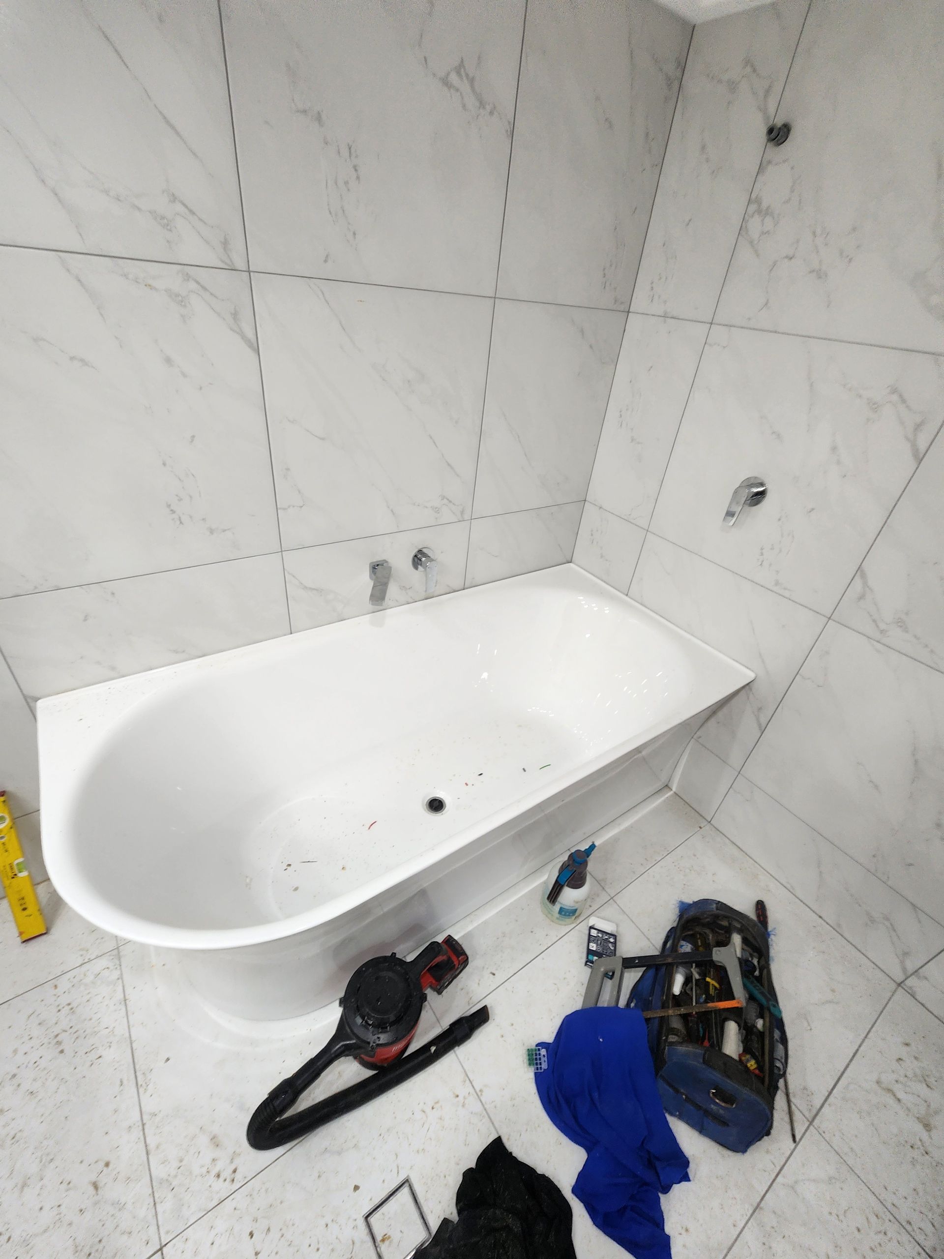 A Hand Holds Two Removed, Worn Metal Faucet Valve Stems — Kingdom Plumbing Services in Gordonvale, QLD