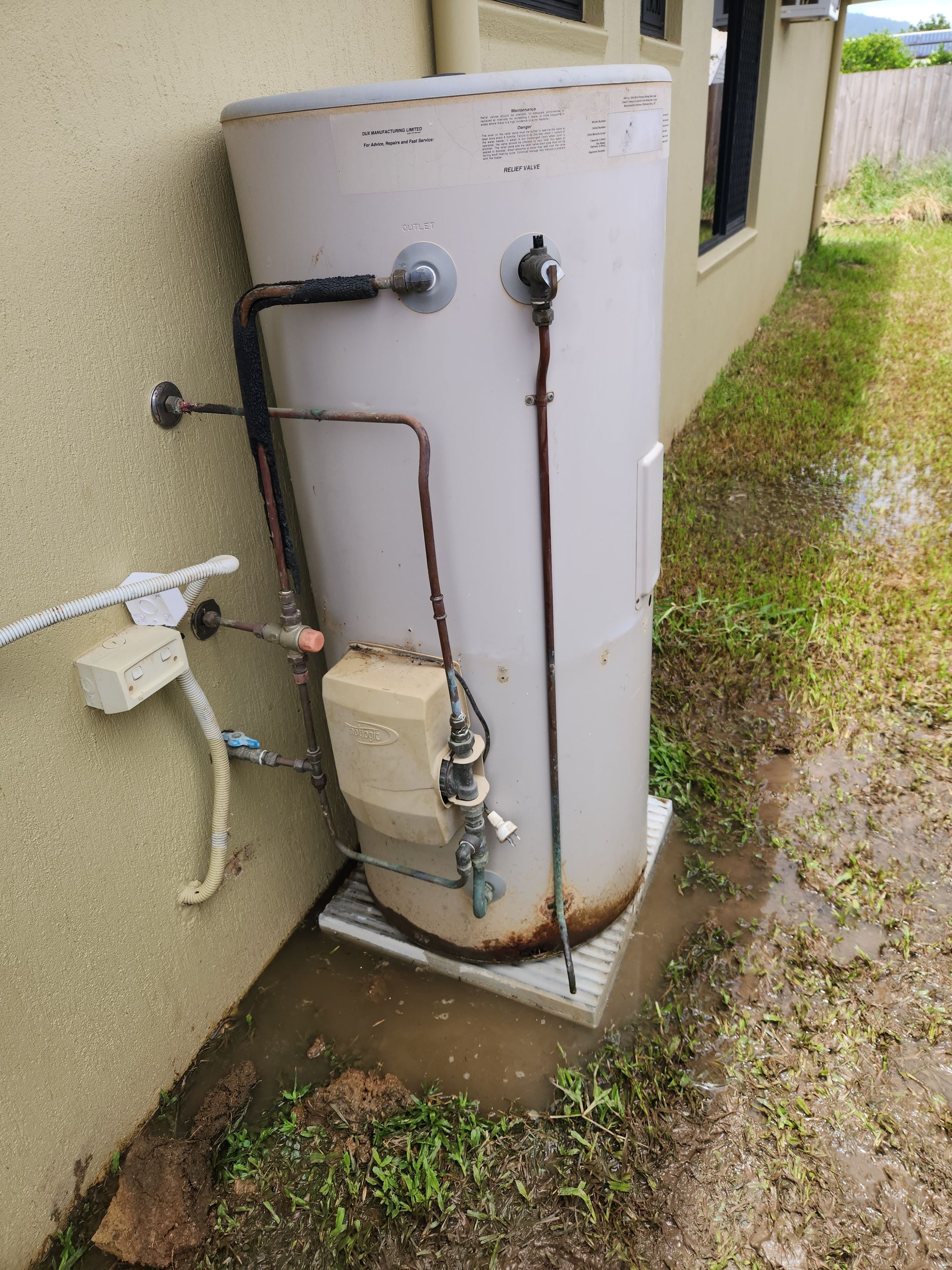 A Water Heater Cylinder Standing on a Concrete Patio — Kingdom Plumbing Services in Gordonvale, QLD