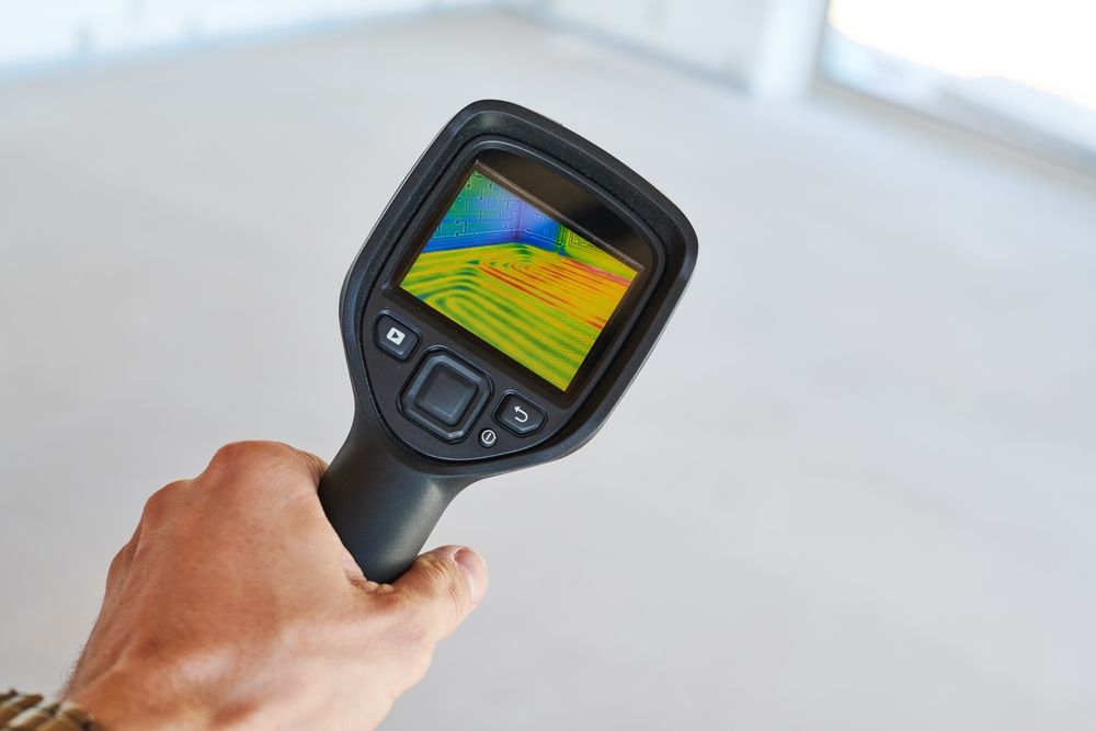 Hand Holding a Thermal Imaging Camera Aimed at a Room — Kingdom Plumbing Services in Gordonvale, QLD