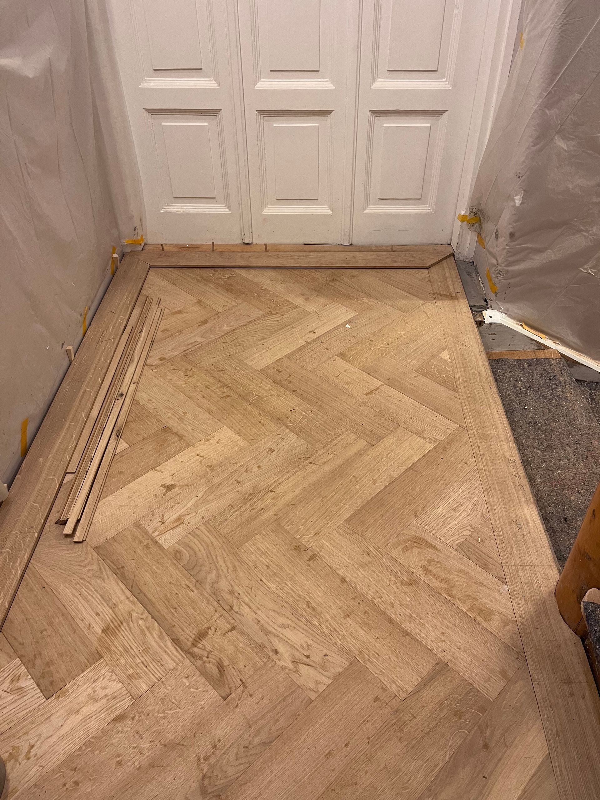 Verlegen von Fischgrät Parkett in einem alten Treppenhaus mit umlaufenden Fries