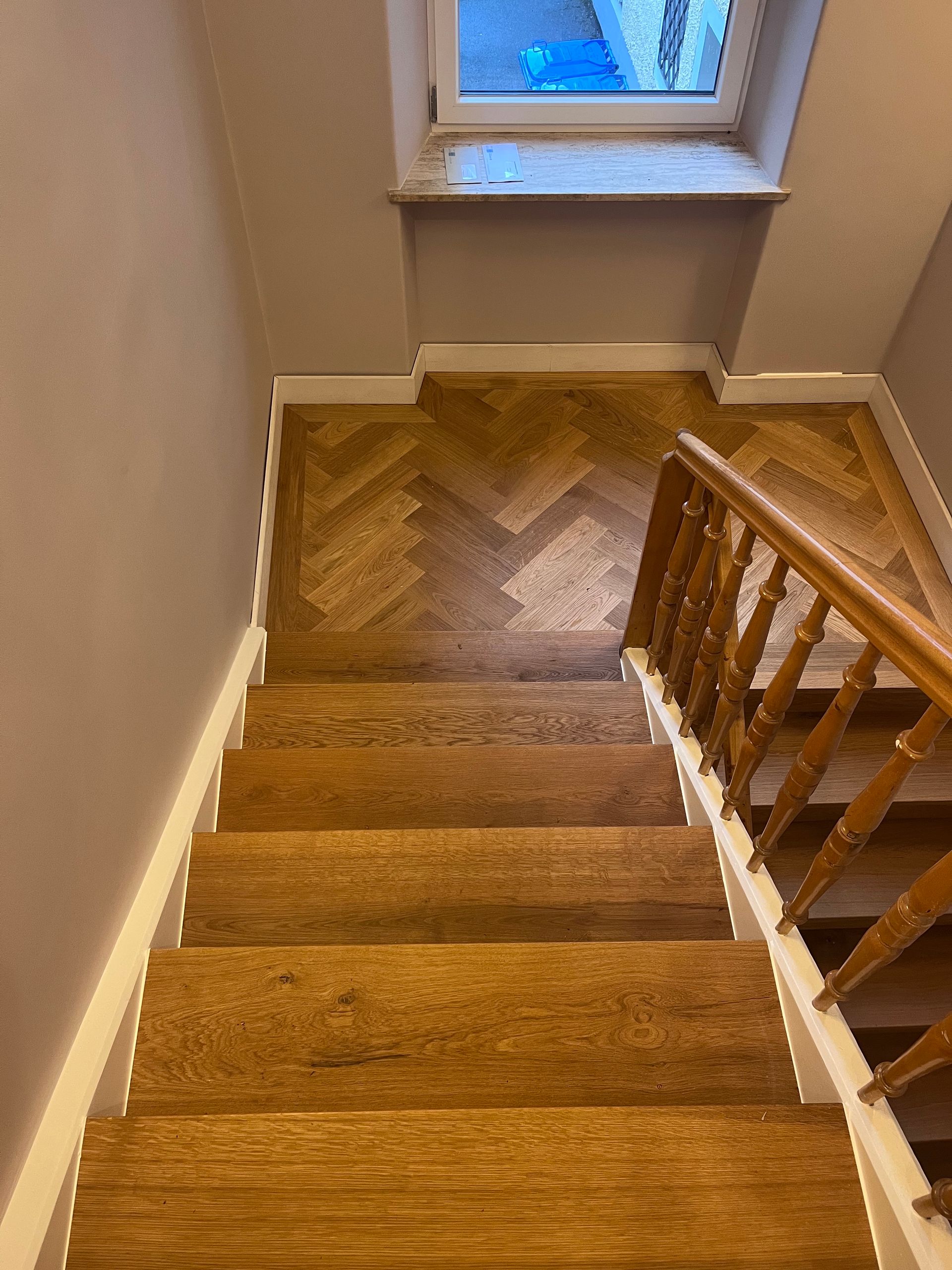 Fischgrät Parkett aus Eiche mit umlaufendem Fries im Treppenhaus