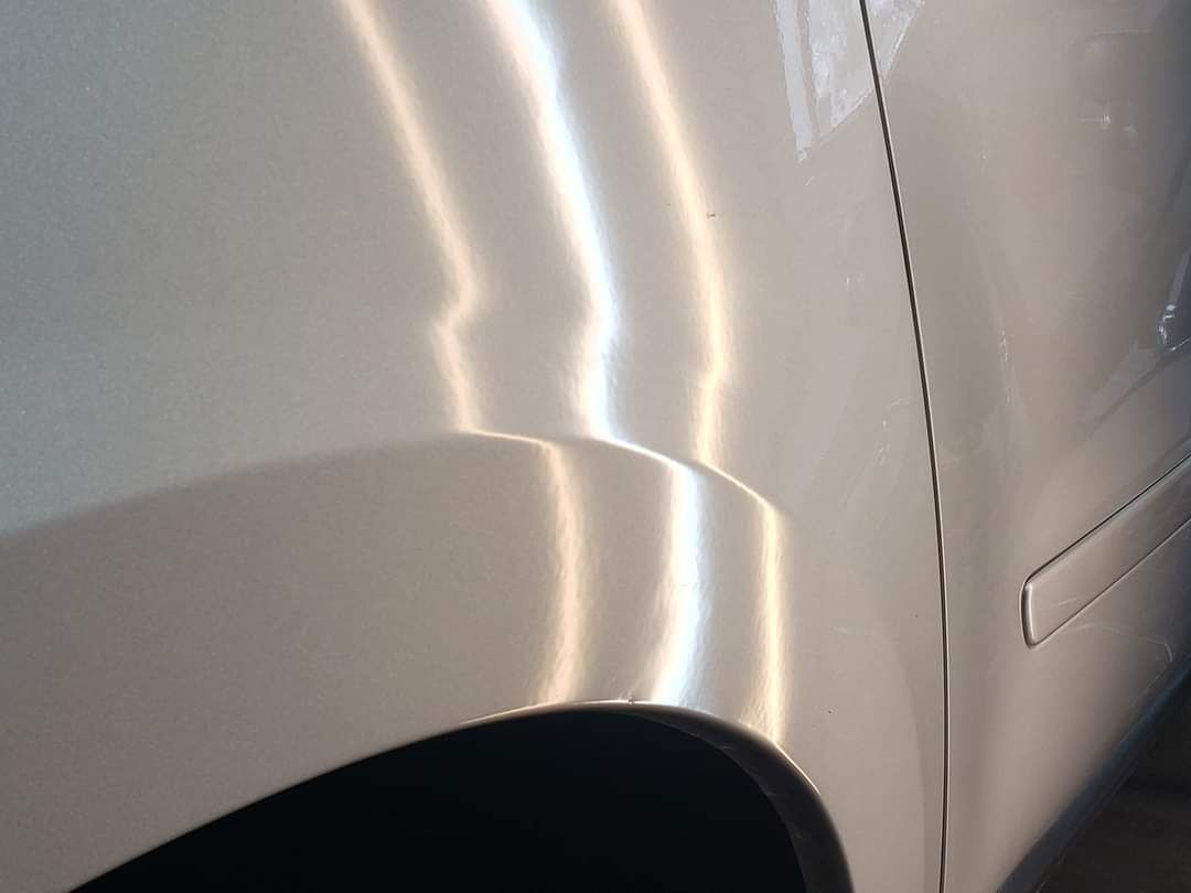 A close up of the side of a silver car