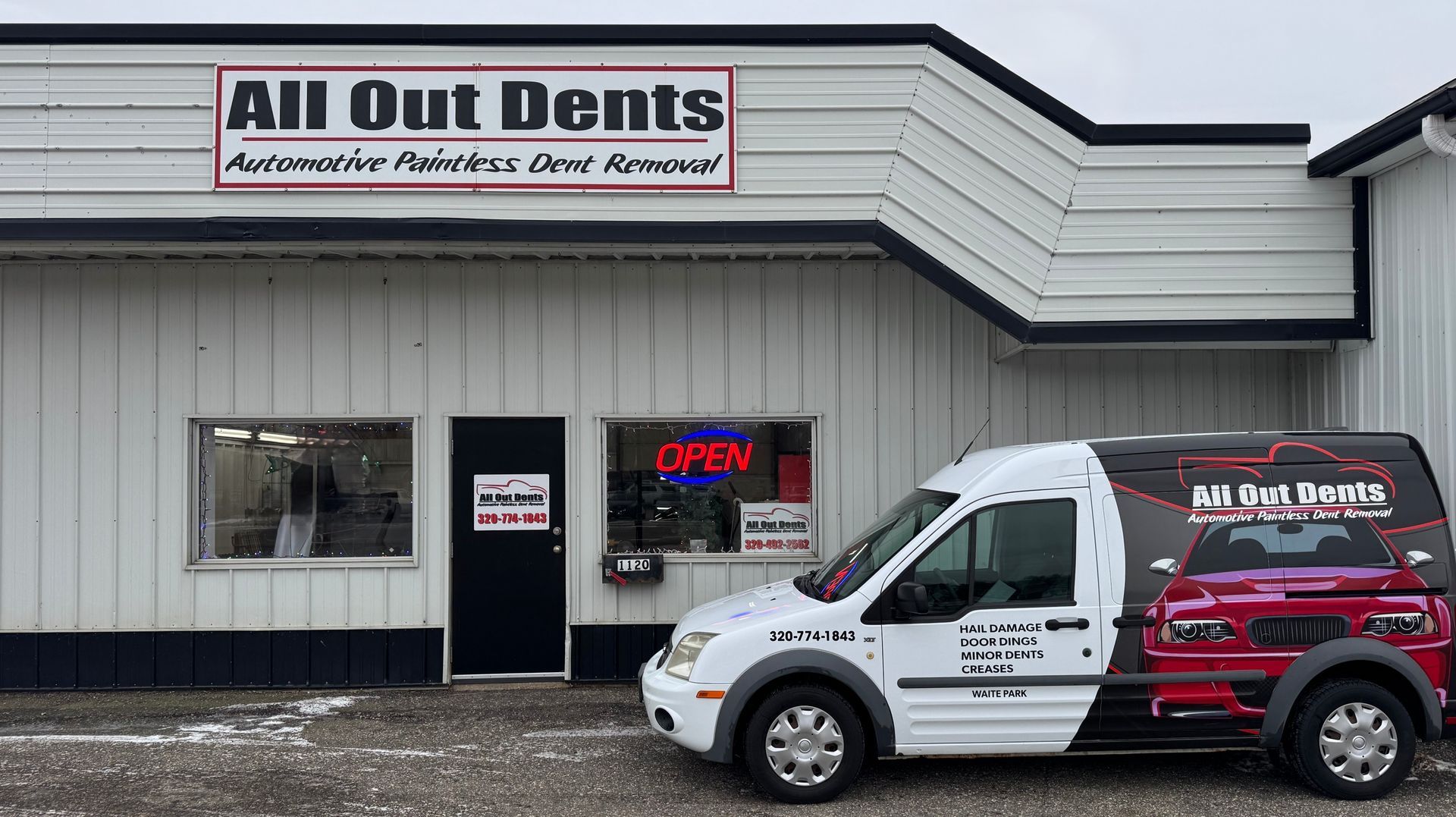 A white van is parked in front of a building.