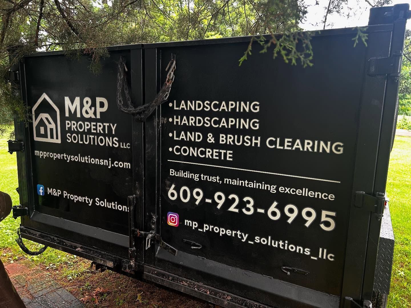 Black dumpster with M&P Property Solutions logo and contact info for landscaping and concrete services.