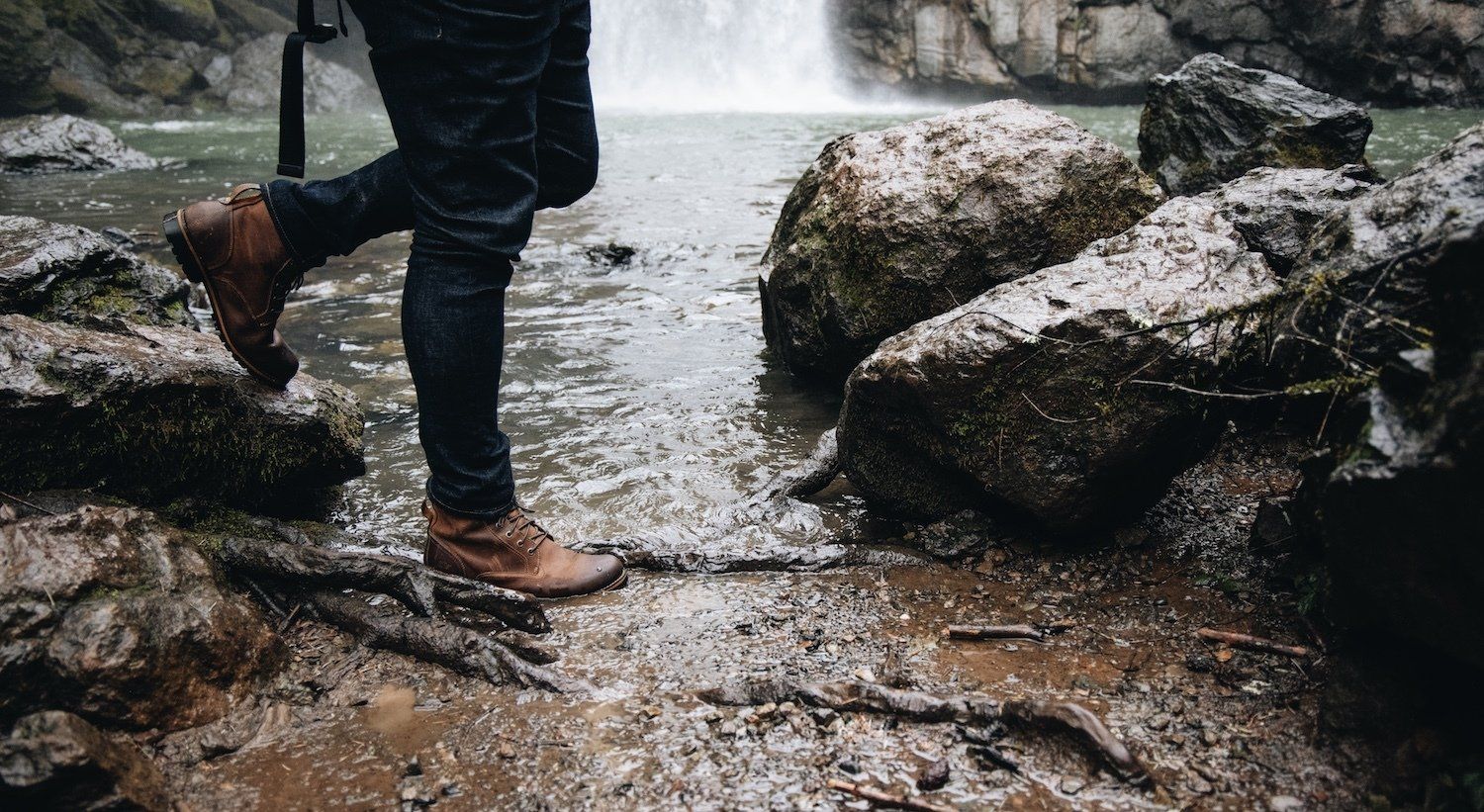 A close up of a man walking through a stream at Lassen National Park.
