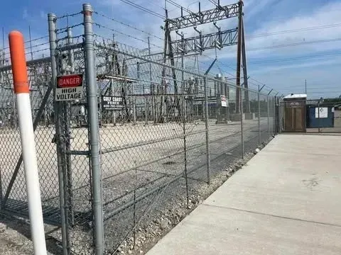 Power substation behind a chain-link fence with a