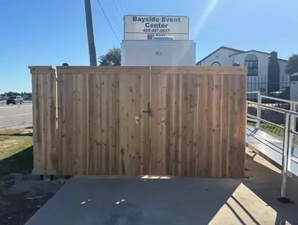 Wooden gate entrance to Bayside Event Center with a ramp for accessibility.
