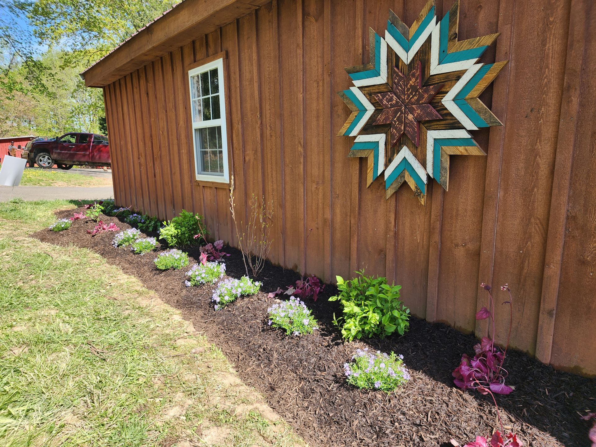 Brown wooden building with flower bed and star decoration.