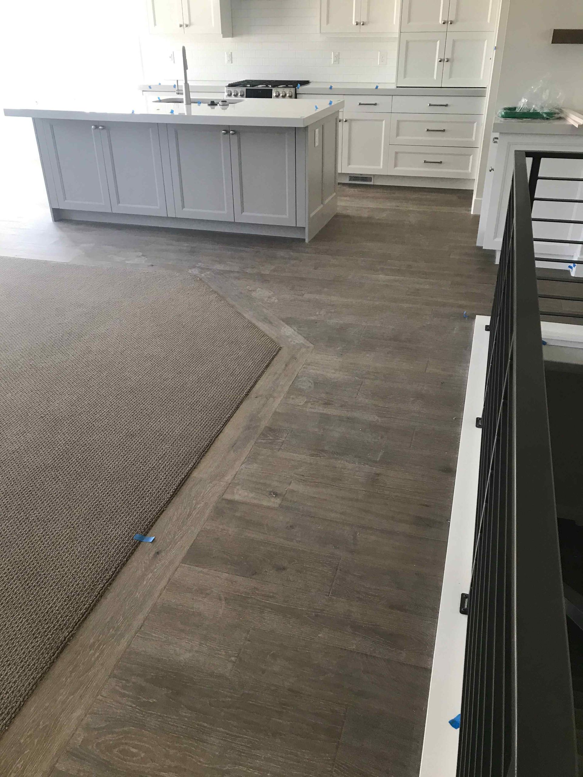 A kitchen with a large island and a rug on the floor