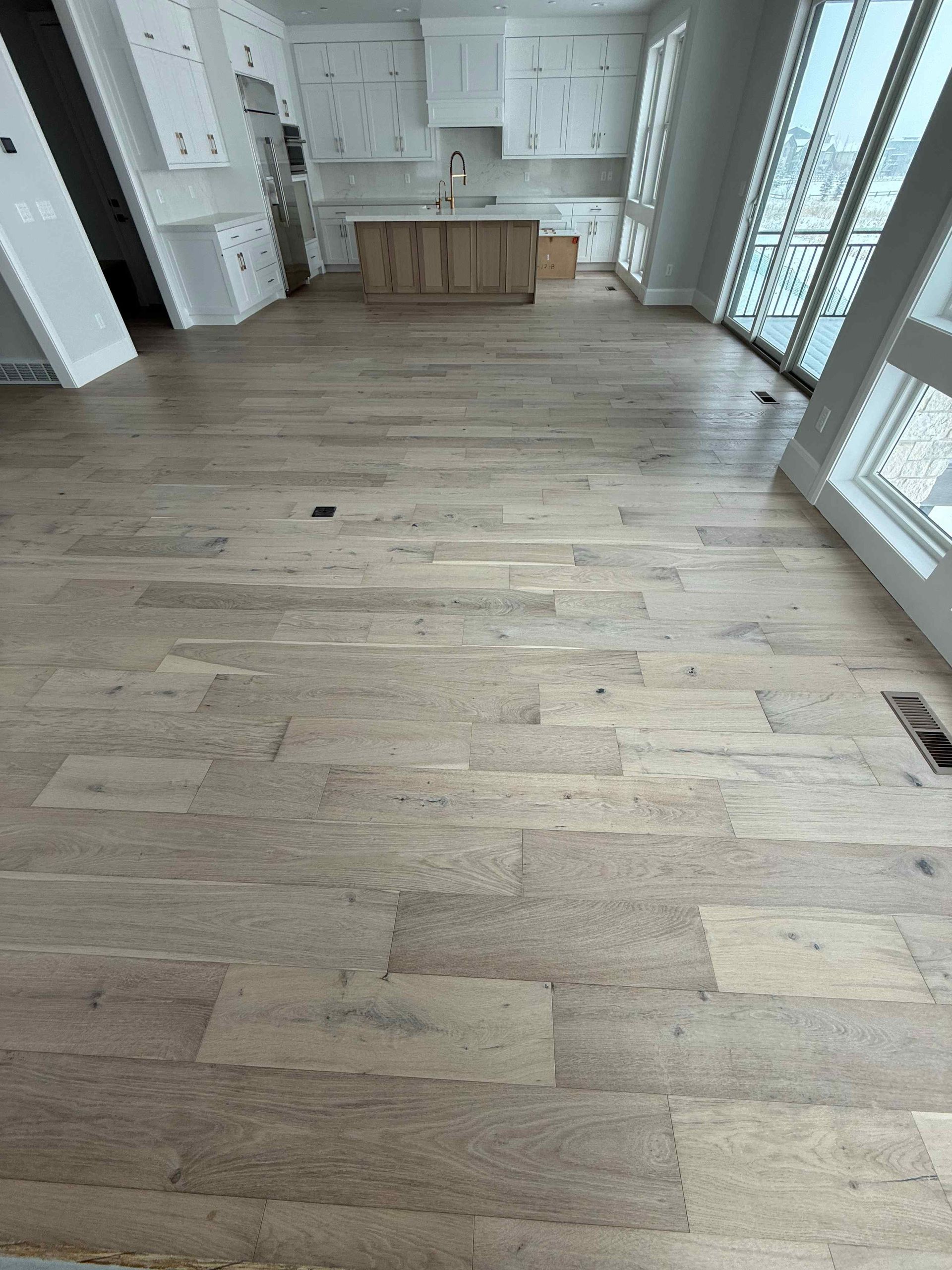 A kitchen with hardwood floors and white cabinets.